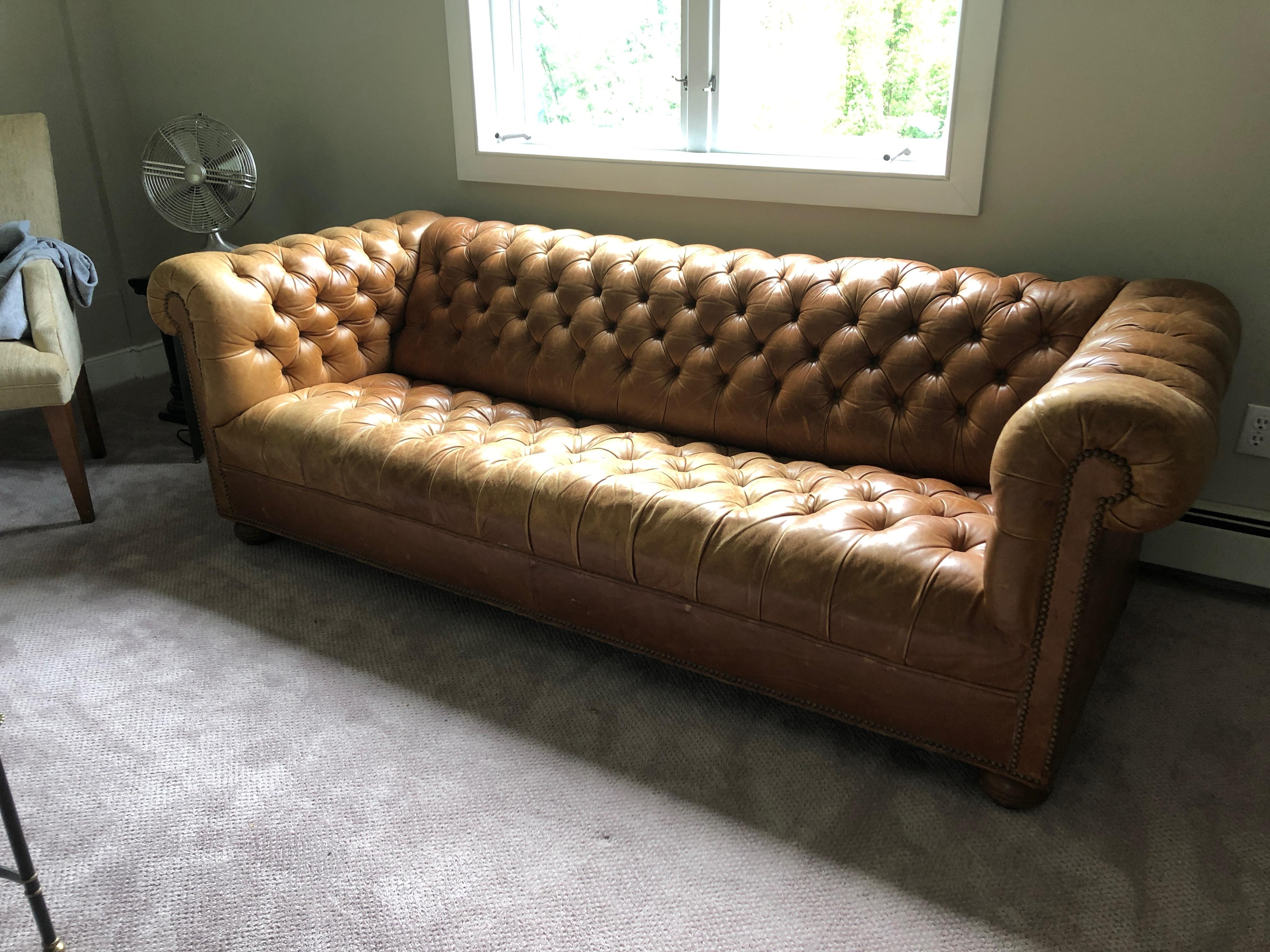 A rare vintage cognac leather Chesterfield sofa having fantastic distressed patina and nailhead detailing. We think it's gorgeous as it is with variation in color due to age, and well worn scratches and imperfections that add character. No rips or