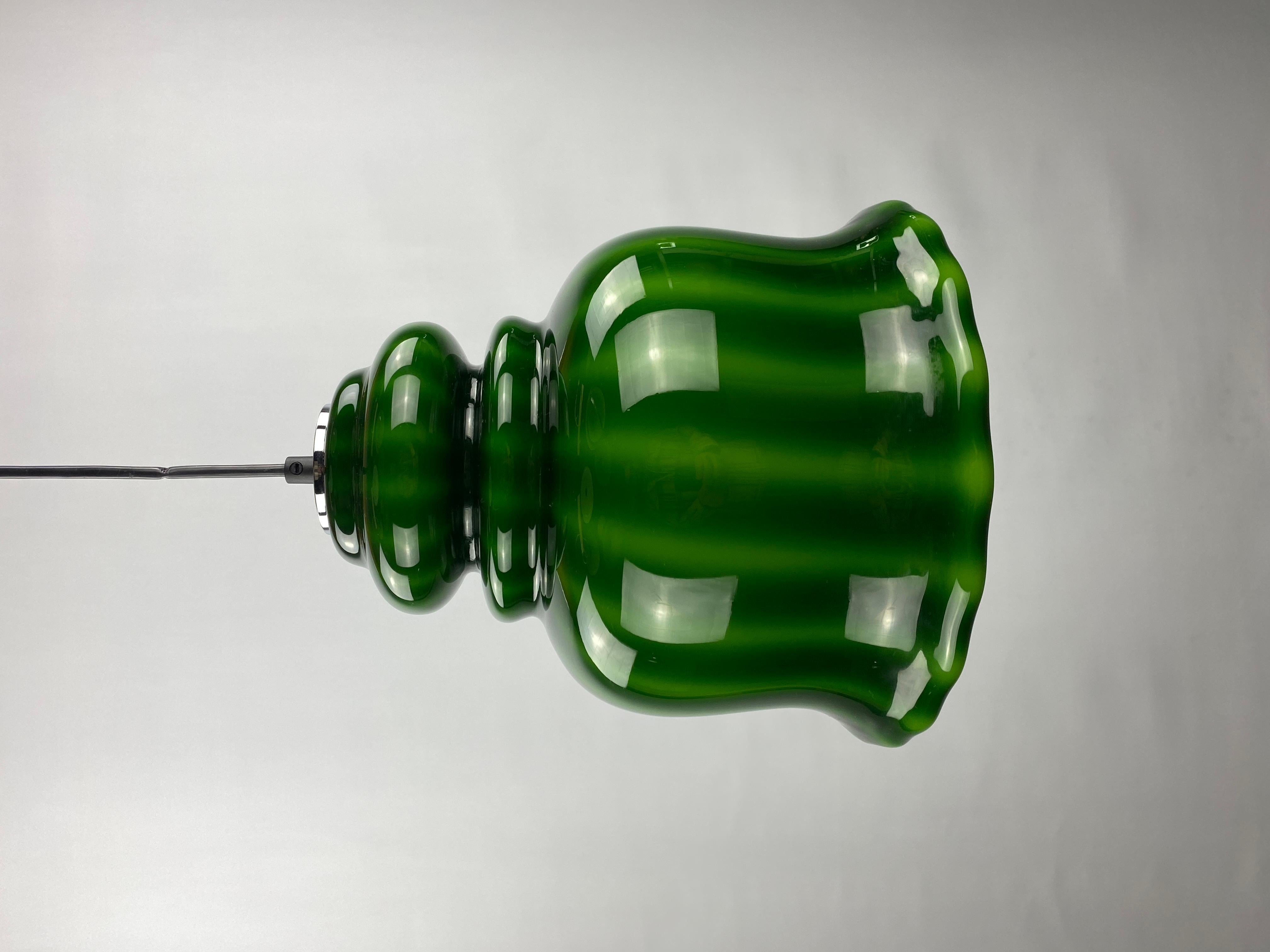 This opaline green watermelon patterned glass pendant light is made by the German company Peill and Putzler around 1960. Has a dark green color when off and when on it gives a very nice soft green light.

Beautiful retro color but still fits in an