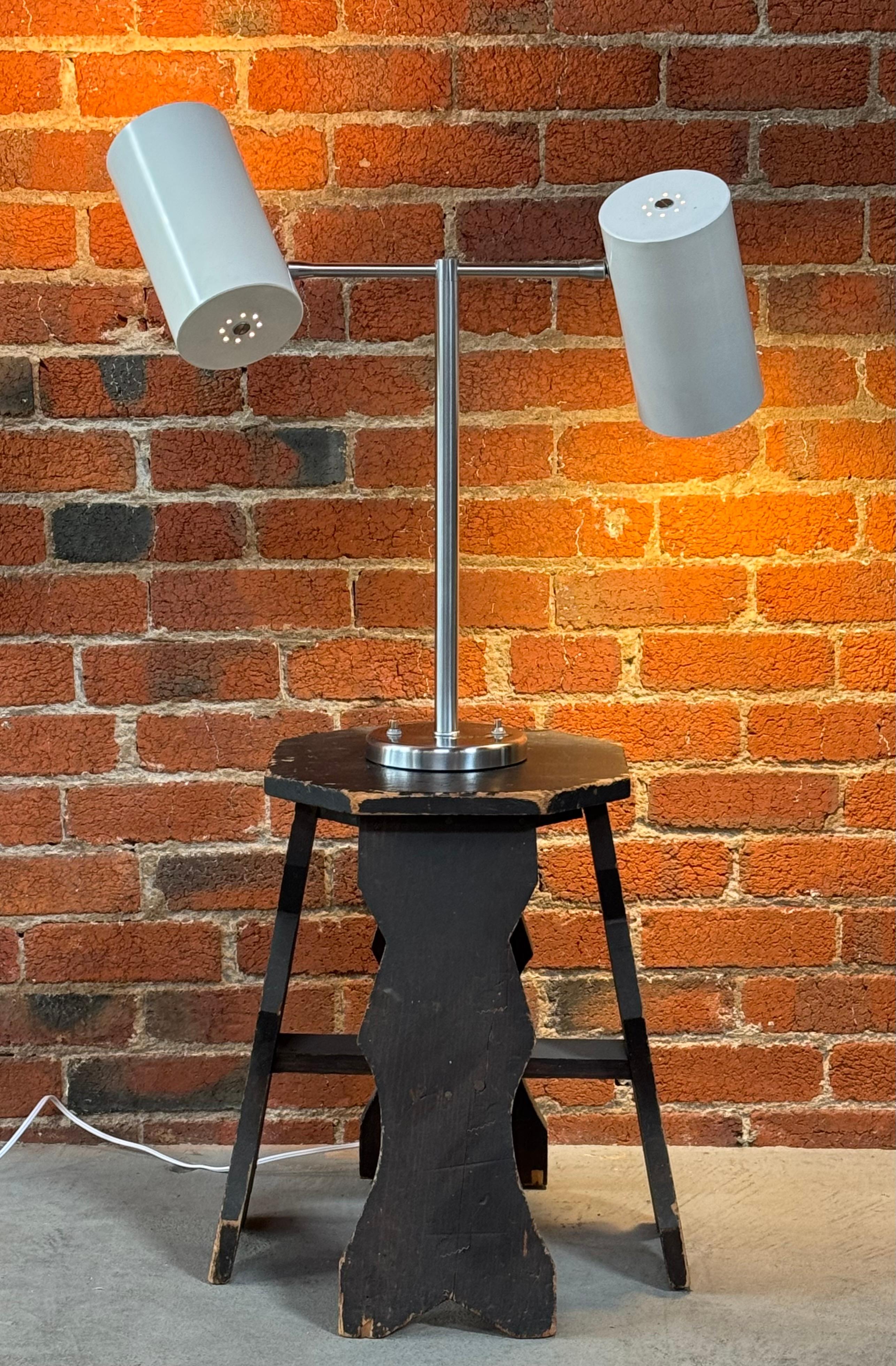 Double cone table lamp by designer Greta Von Nessen, her her company Nessen Studio, Inc circa 1950s having a soft white cylindrical shade crafted out of turned aluminum with a solid brass base and stem plated in a stain chrome. The shades can be