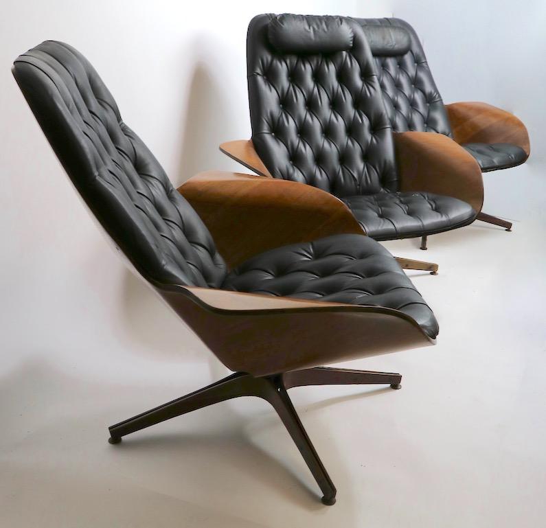 Rare opportunity to purchase a set of Mulhauser Mr. Chairs. The lot includes three swivel lounge chairs, two having the original pillow headrest, and two swivel footrest ottomans. All show varying degrees of cosmetic wear, tears to vinyl upholstery,