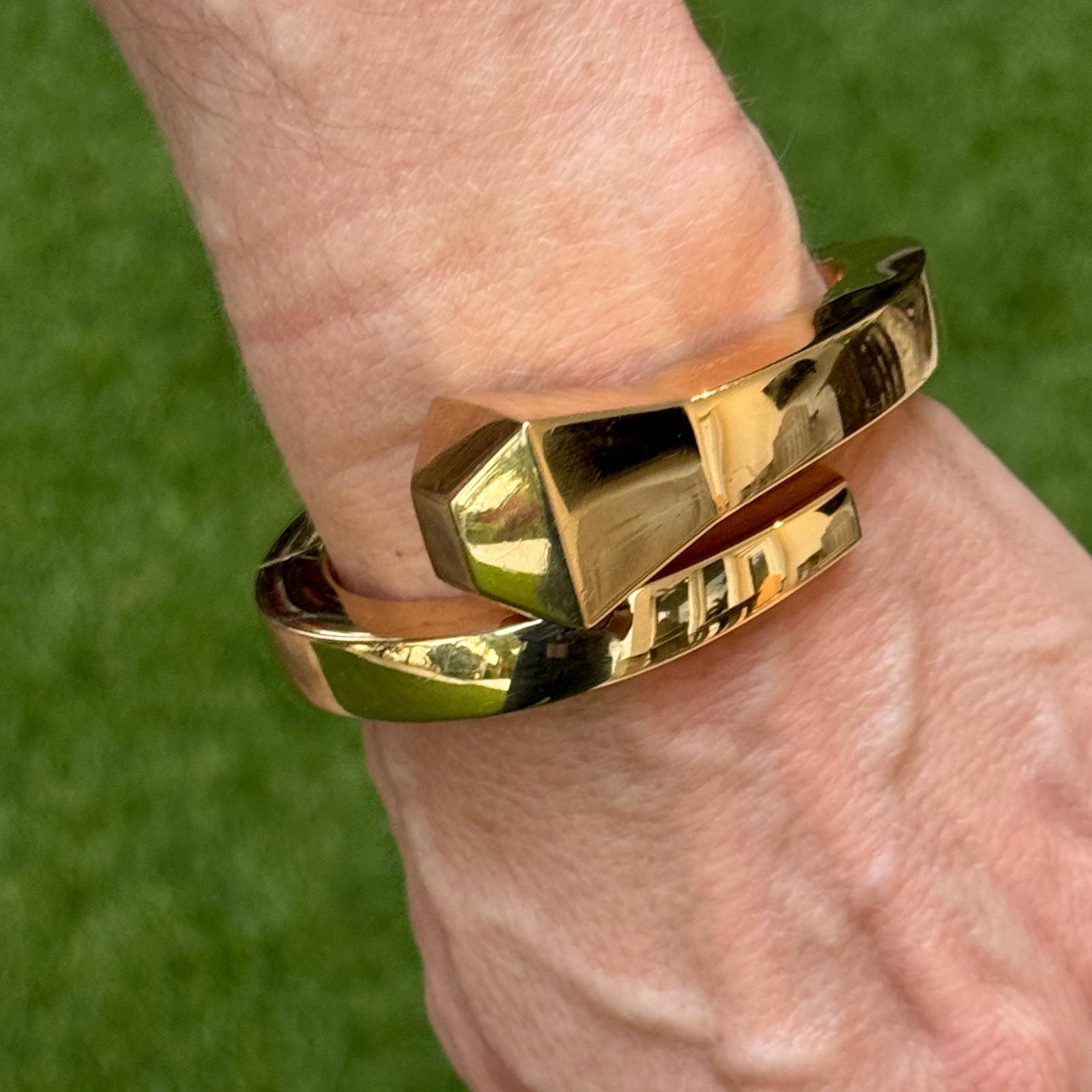 This very rare Gucci Chiodo hinged bypass bracelet is a striking and unique piece that exudes luxury and sophistication. Featuring a bold, modern design, the cuff bracelet is crafted with impeccable craftsmanship, combining polished metal with