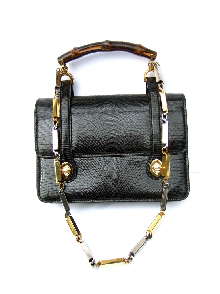 Extremely rare Gucci Italian black lizard leather handbag - shoulder bag c 1970s
The chic retro Italian structured handbag is constructed with a glossy 
black lizard skin leather covering 

Adorned with Gucci's iconic wood bamboo handle. Paired with
