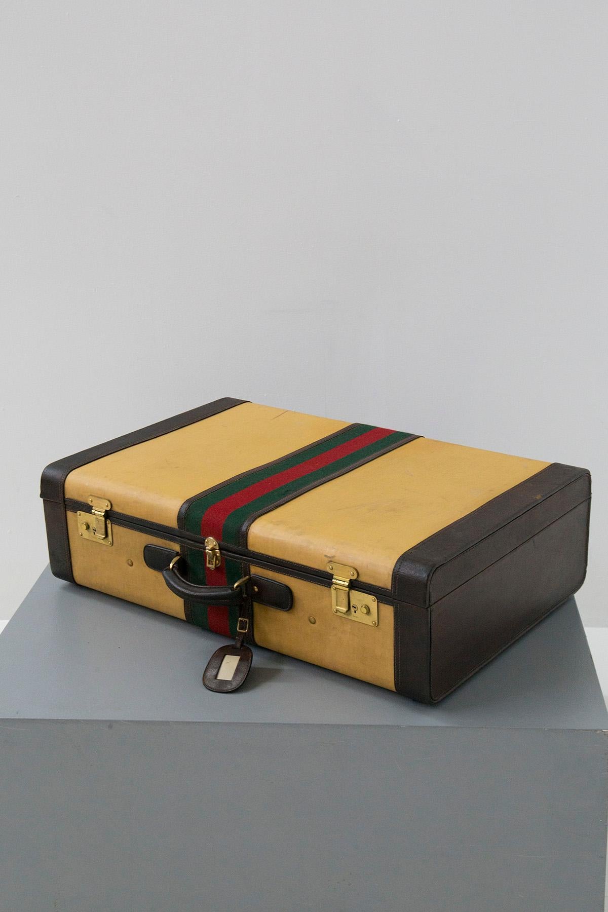 Rare and elegant Gucci signature travel suitcase from the 50s-60s. vintage. Made of rigid structure and lined with light fabric . Note the band representing the institutional colors of Gucci manufacture surrounding the bag in red and green cotton
