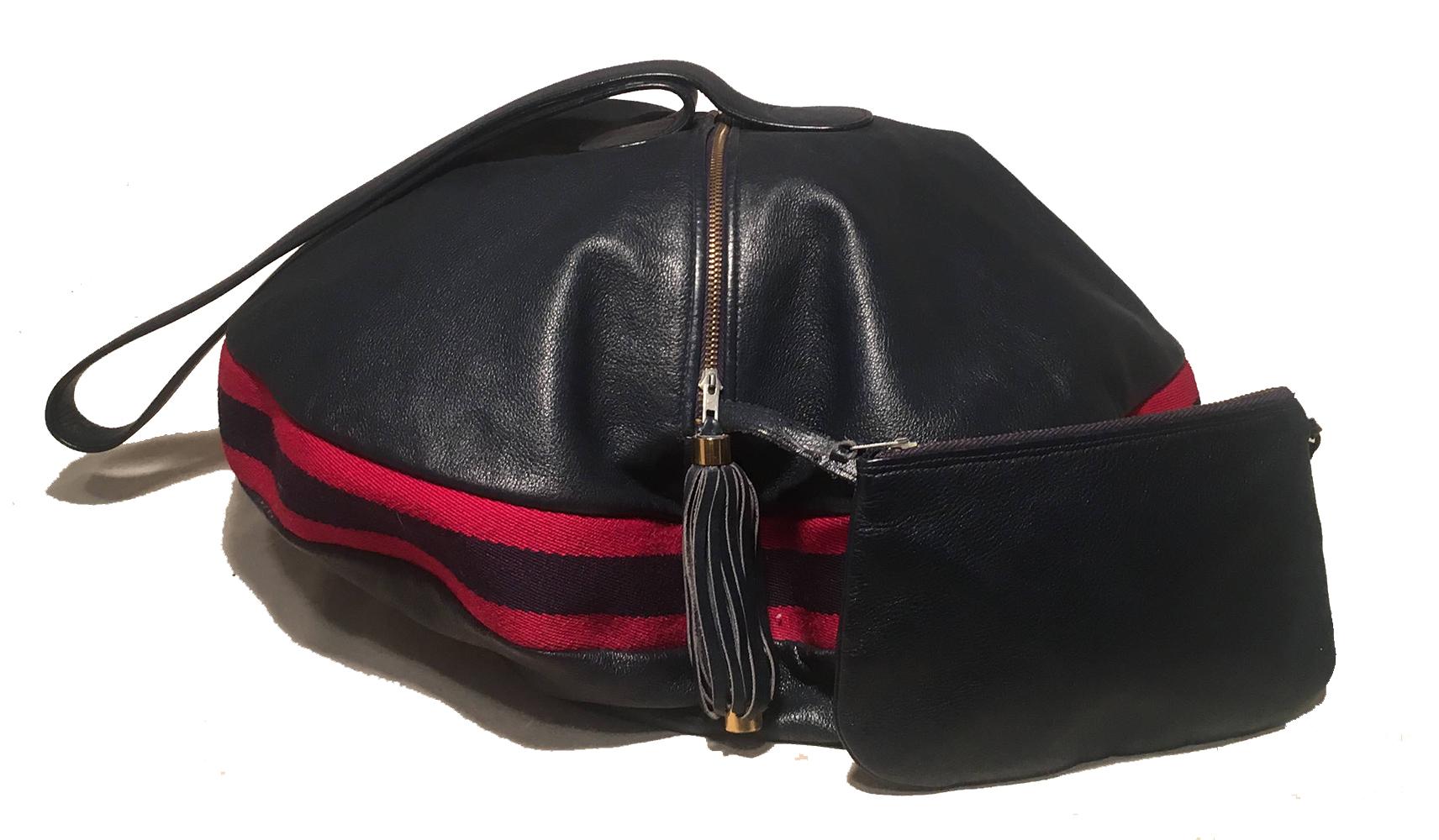 RARE Gucci Vintage Navy Leather Striped Canvas Shoulder Bag in very good condition. Navy blue leather exterior in unique flying saucer shape trimmed with signature red and navy canvas stripes around middle. Top zipper closure opens to a navy woven