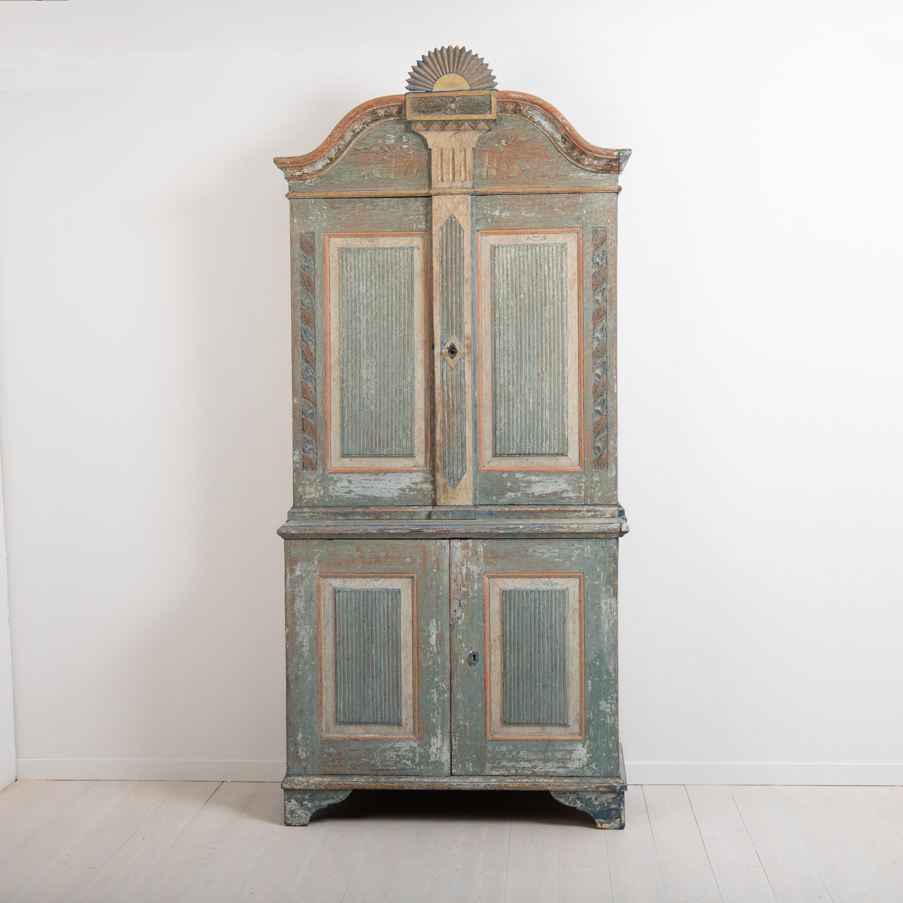 Rare Gustavian cabinet from Hälsingland dated 1816. Likely made by master carpenter Olof Brink Alfa. Dry scarped to original paint. Very richly decorated with unusual carved wooden decorations in the shape of leafs on the sides. Doors with fluted