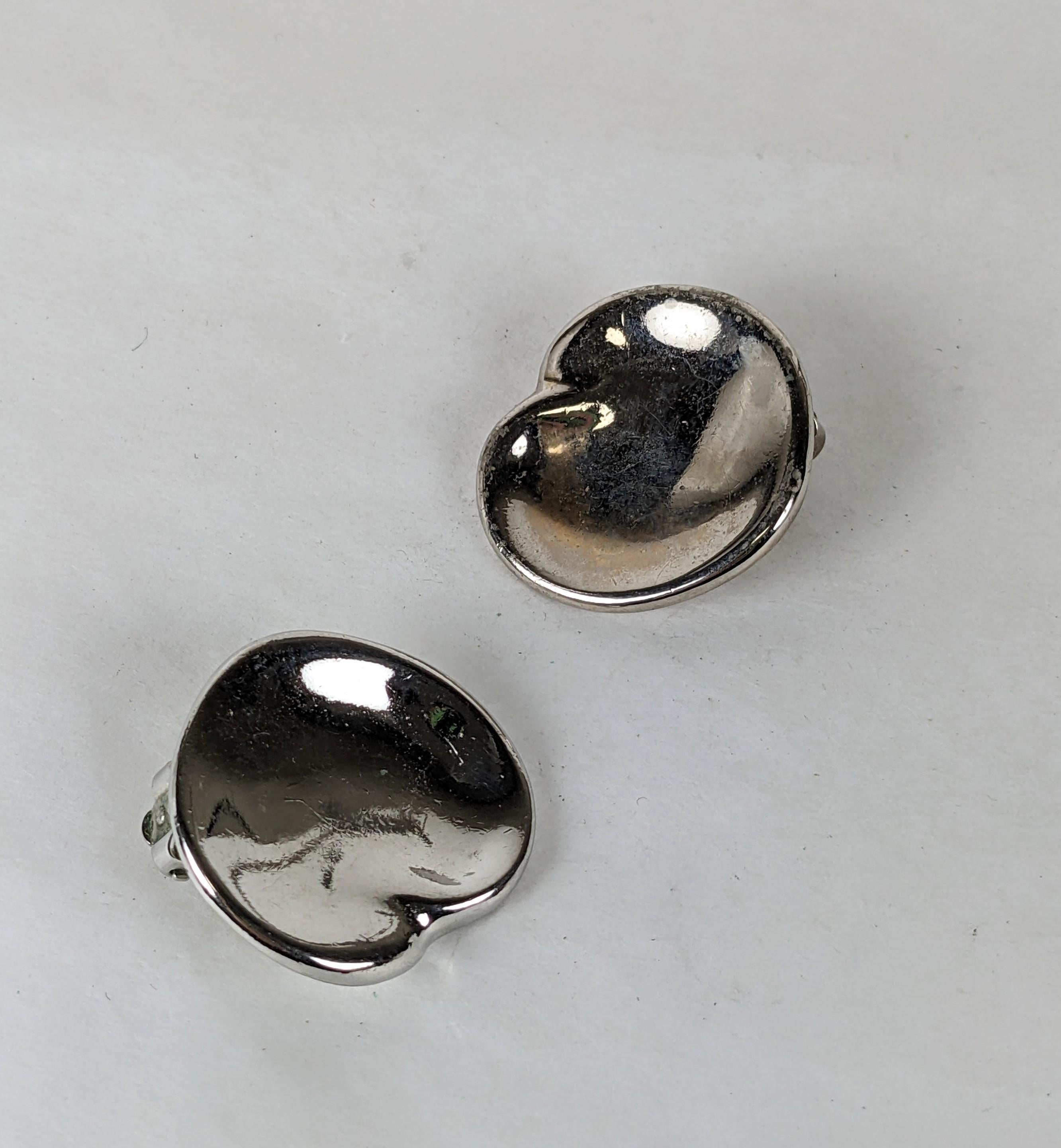 Rares boucles d'oreilles en forme de cœur par Halston, datant des années 1970. Design en métal argenté inspiré d'Elsa Peretti mais étiqueté pour la ligne Halston. 
Très peu de bijoux ont été produits par Halston. Années 1970, USA. 
Raccords à clip,