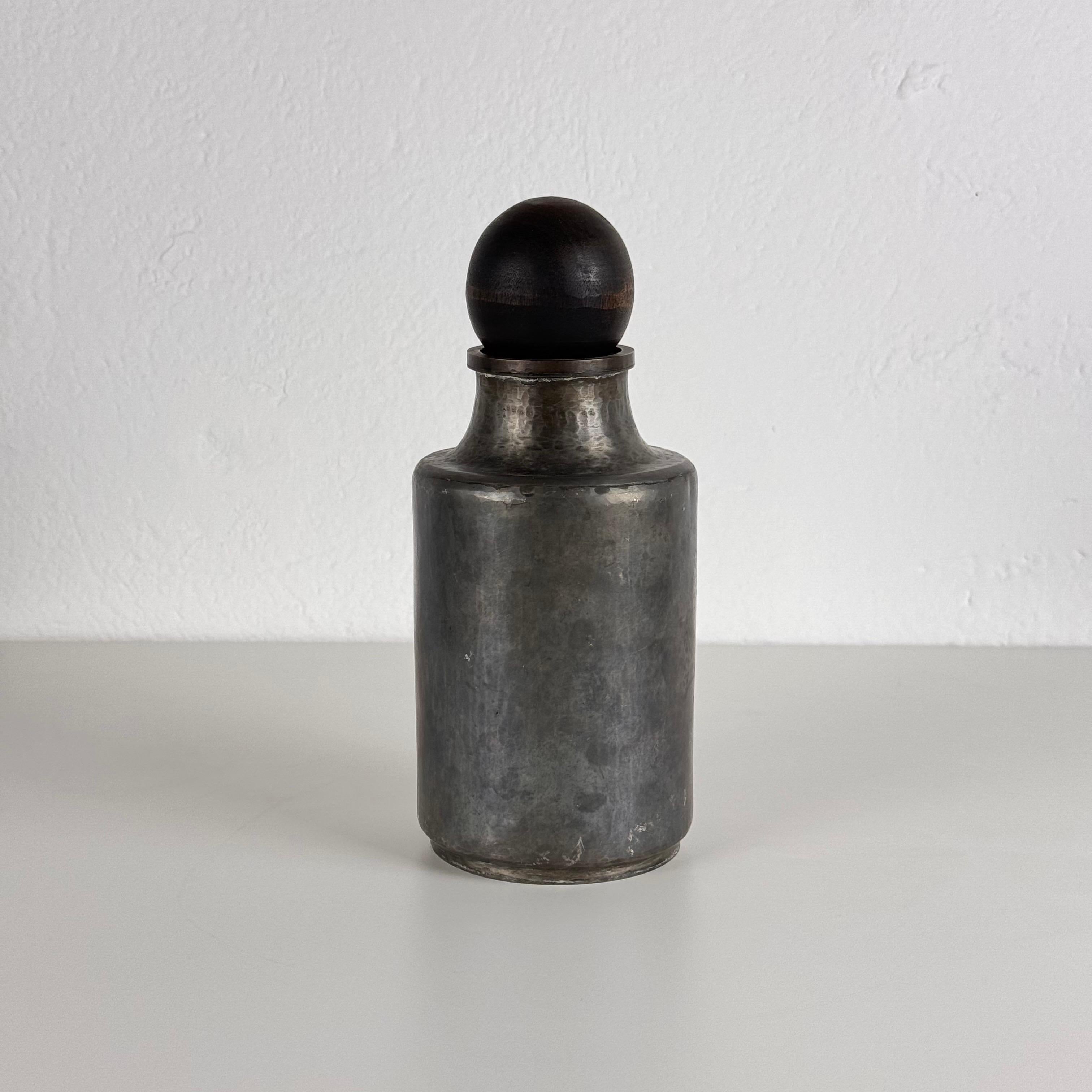 Una rara e squisita bottiglia decorativa del celebre designer e scultore Lorenzo Burchiellaro, noto per la sua padronanza dei metalli e per la sua capacità di fondere l'espressione artistica con il design funzionale. Questo pezzo firmato, realizzato