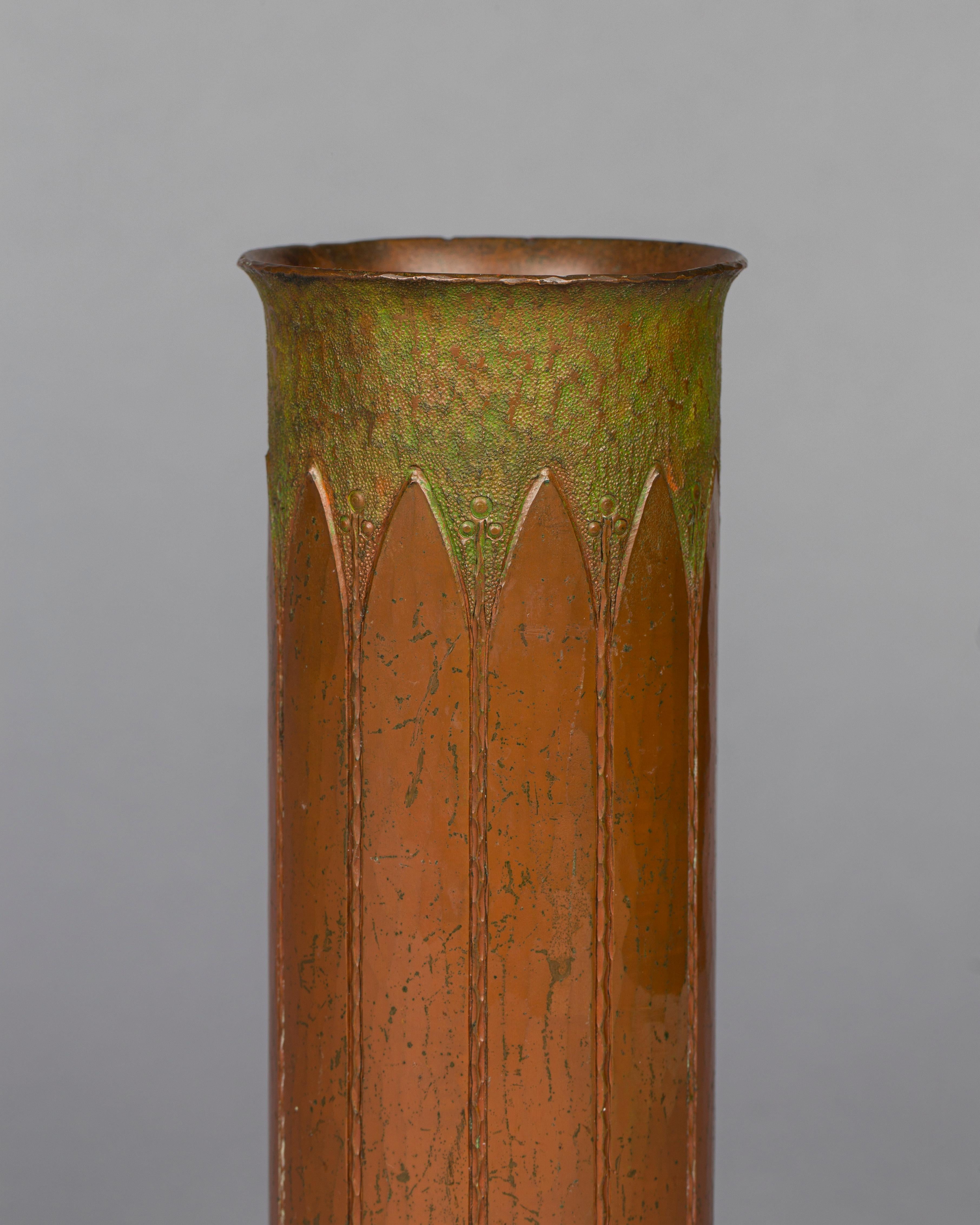 Roycroft
Rare hammered copper cylindrical vase incised with full-length leaves alternating with
buds beneath a verdigris-patinated hammered top, circa 1910-1915
Design by Walter Jennings
Orb and cross mark.
