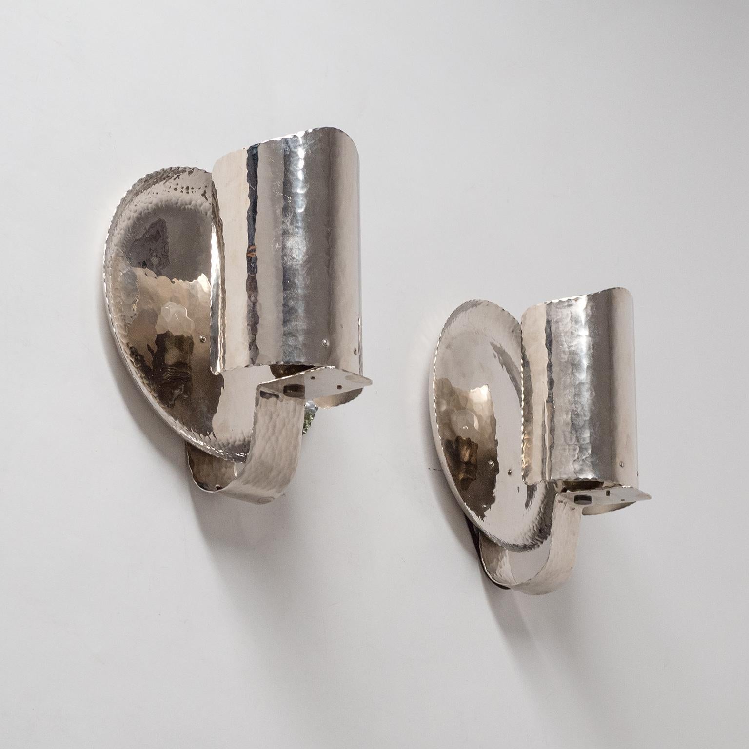 Very rare pair of nickel Art Deco sconces from the 1930s. Made entirely of nickel-plated hammered brass, even the edges are hammered. The uneven surface and edges provide a rare organic quality which contrasts nicely with the sheen of the nickel.