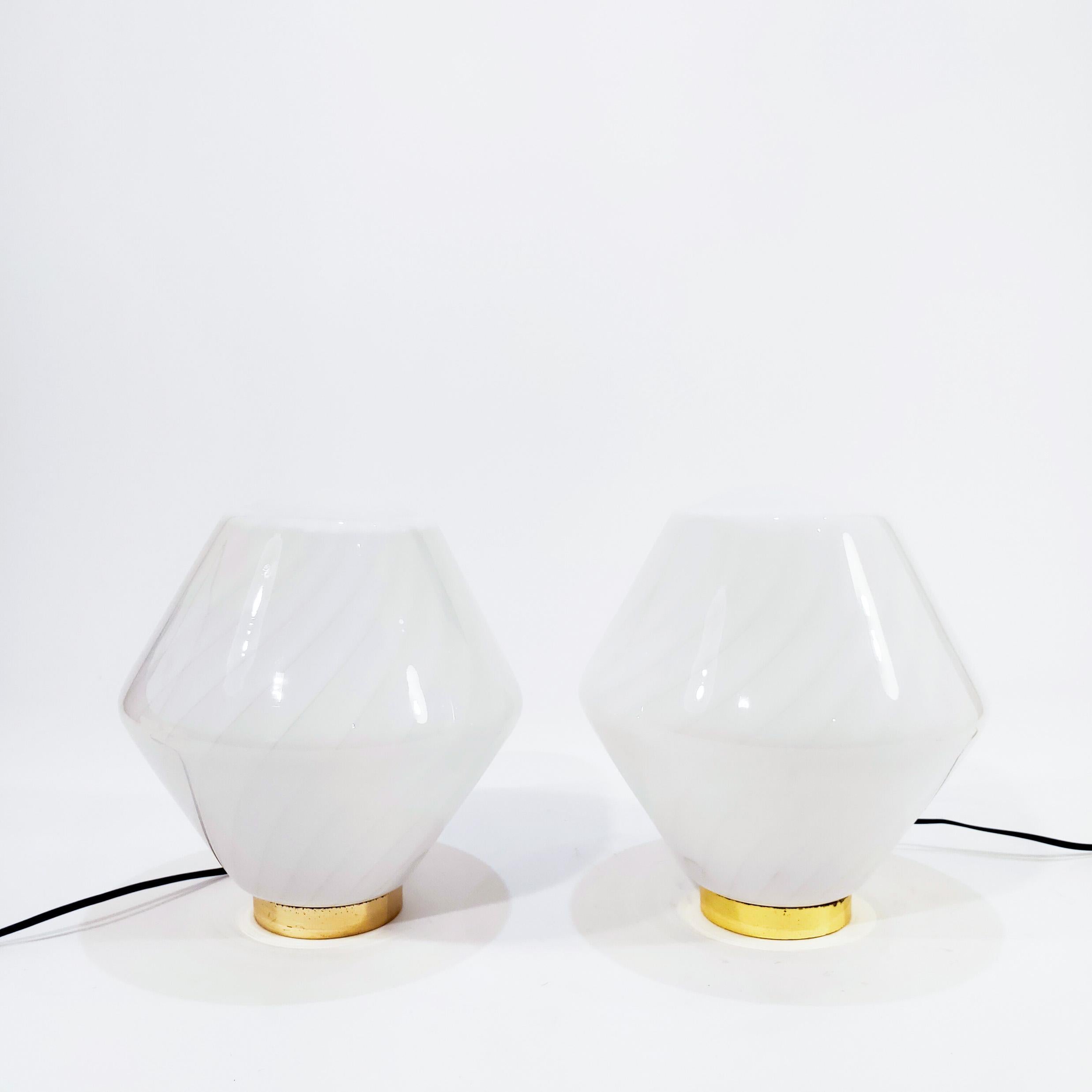 Pair of Space Age style Italian table lamps from the 70s, designe by F. Fabbian for Mazzega. Murano glass body contrasting milky white and semi-transparent in the form of a swirl. Gold chromed metal base.
For one E27 bulb each piece. Original