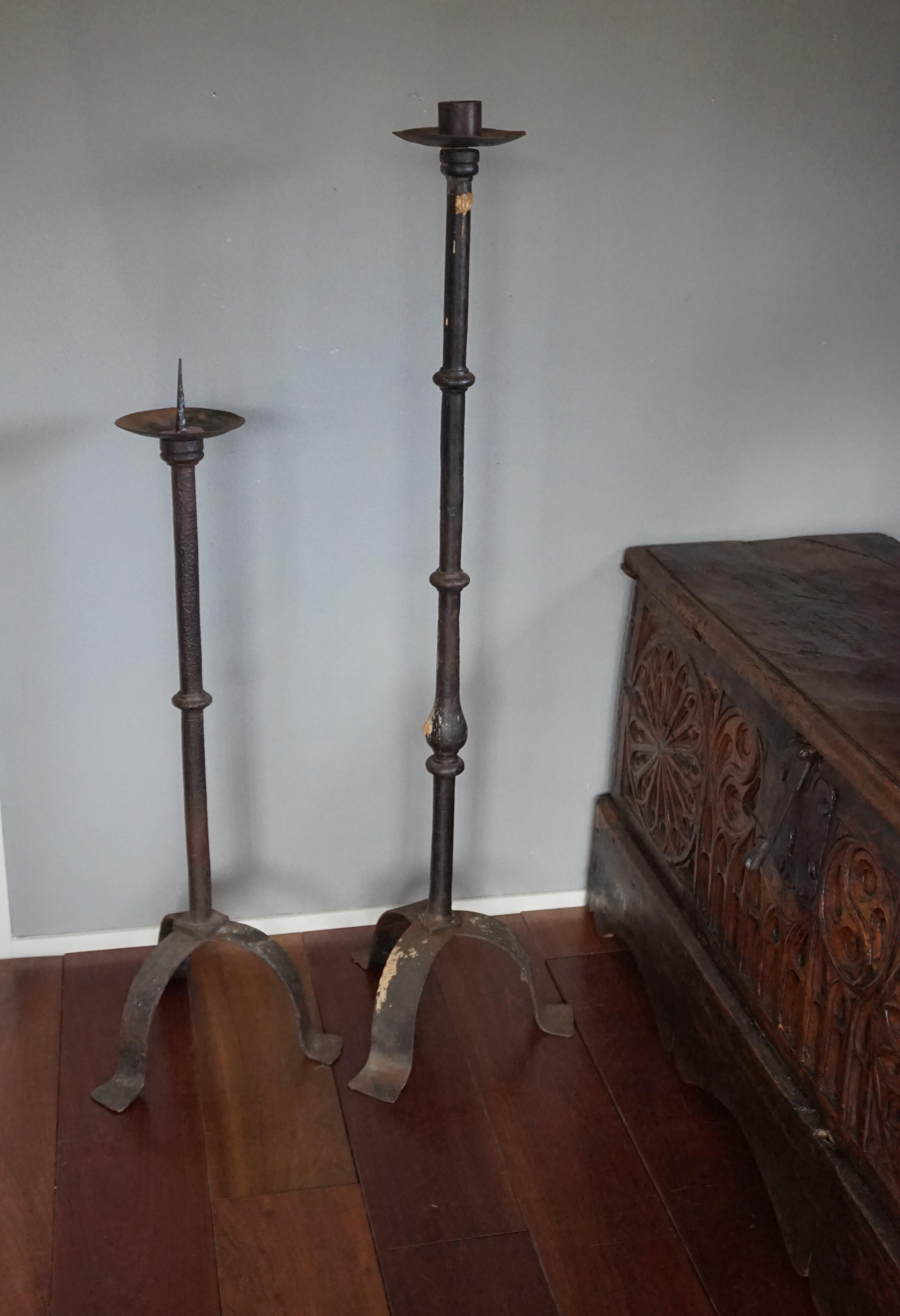 Handcrafted and highly decorative pair of antique floor candlesticks.

These rare and hand forged, 19th century candlesticks will look particularly marvelous in a mediëval or Gothic style interior. They aged beautifully which has given them their