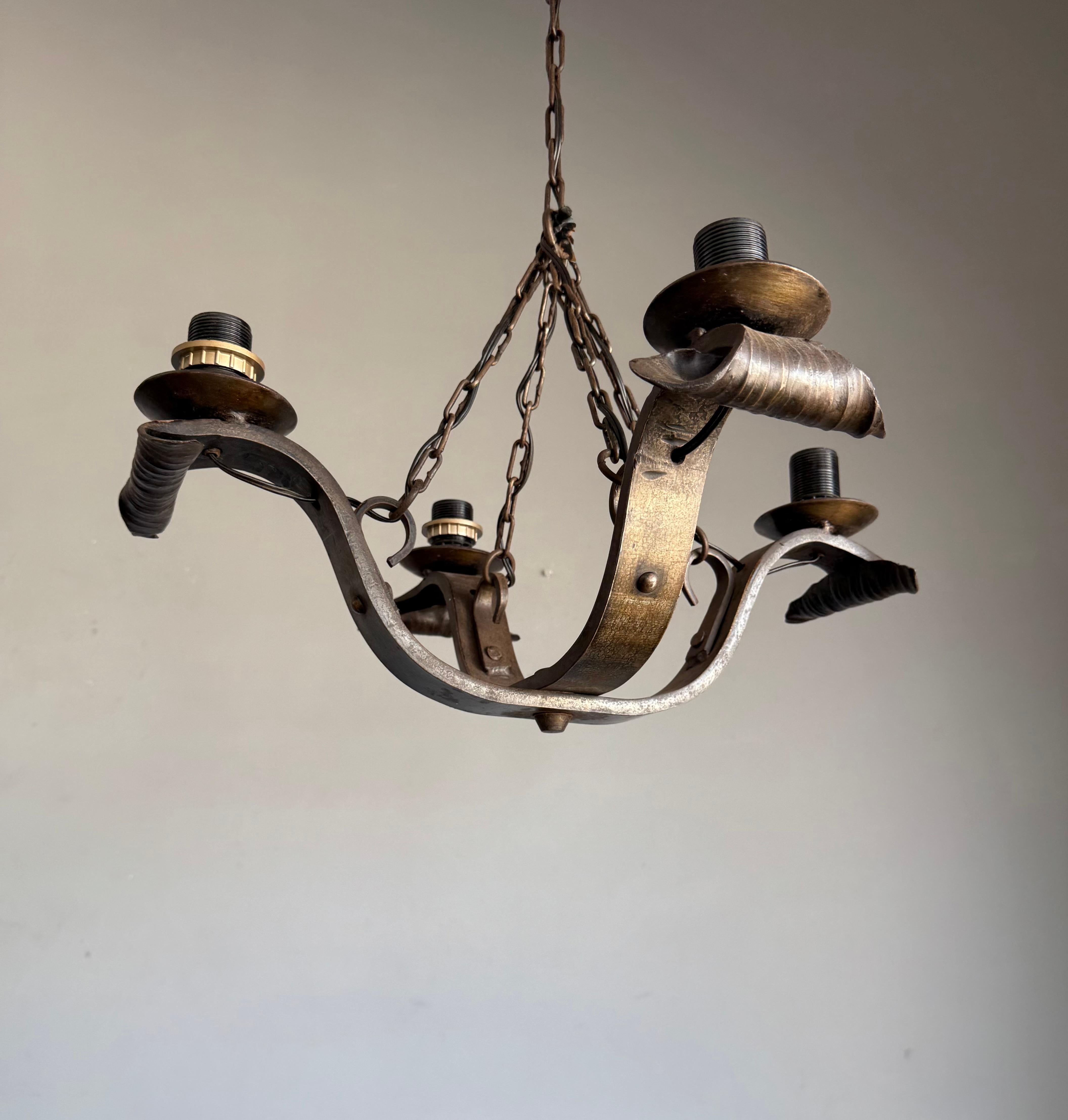 Brutalist all-handcrafted pendant light.

A striking example of traditional blacksmith craftsmanship, this hand-forged 4-light chandelier is a bold and timeless lighting statement. Constructed from heavy wrought iron, the chandelier features