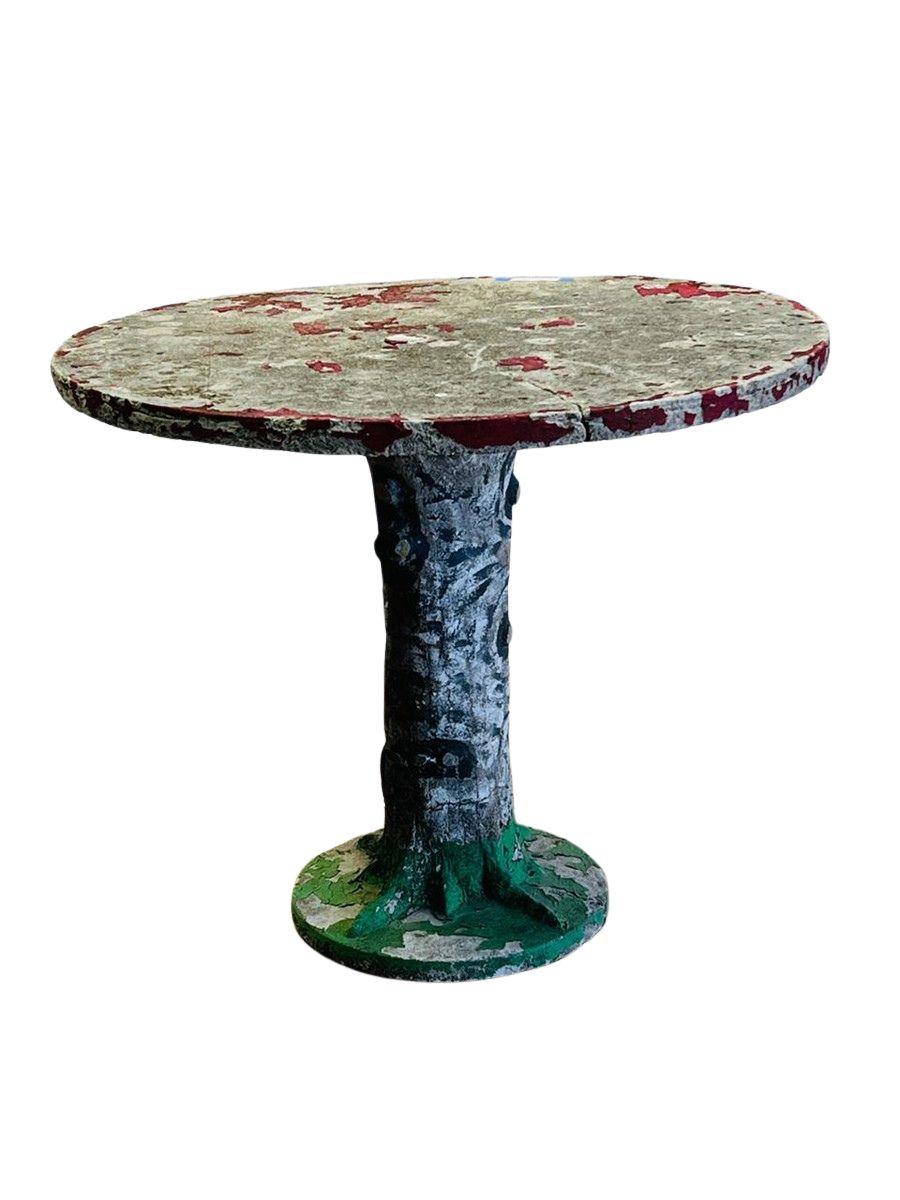 Une table de jardin en faux bois peinte à la main, rare et saisissante, mêlant l'art populaire et le design brutal à un savoir-faire sculptural. Conçue pour imiter la texture organique de l'écorce d'arbre, cette pièce fantaisiste et audacieuse
