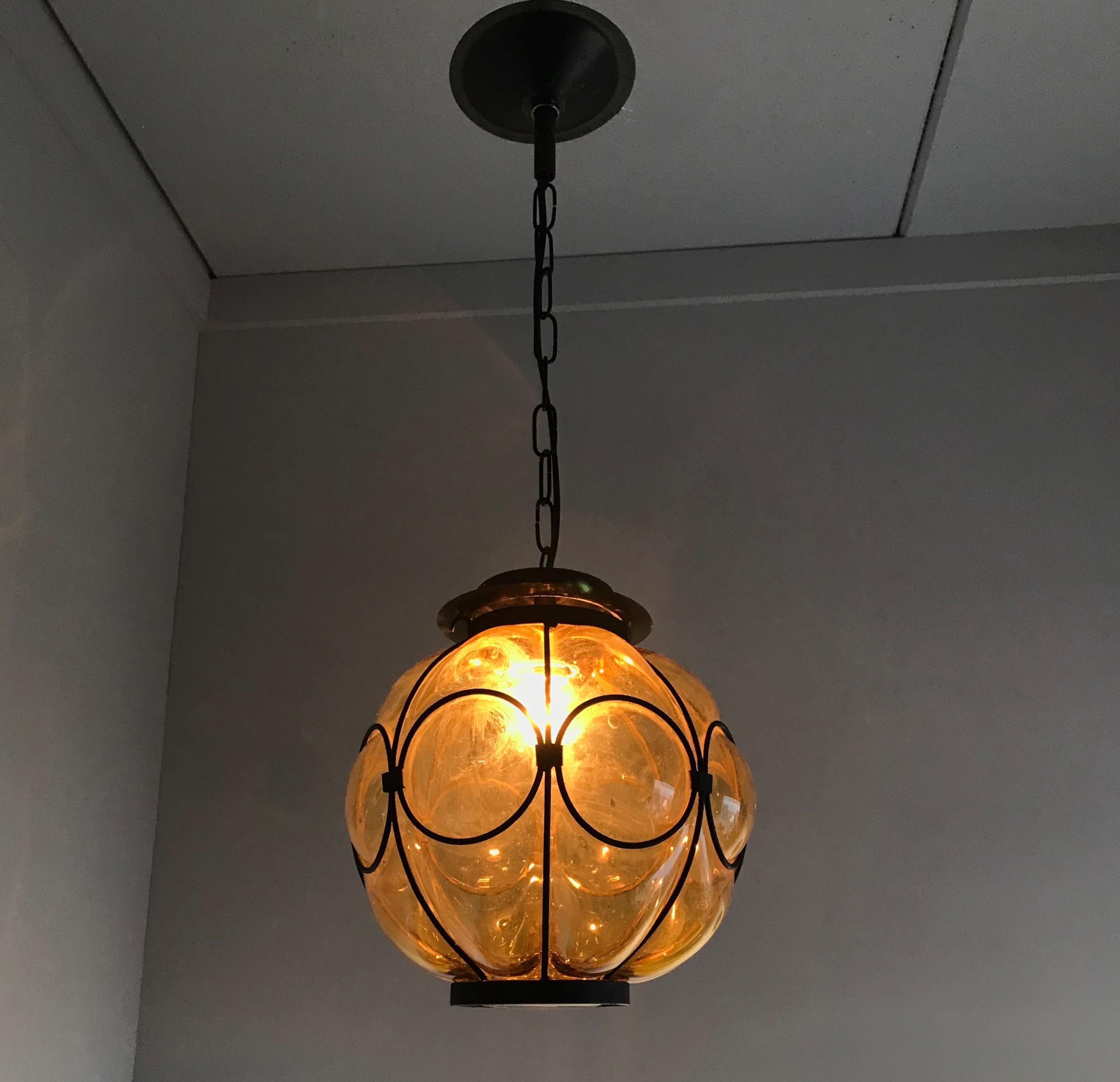 Timeless, circular design Venetian pendant.

This rare, midcentury pendant is mouthblown into a perfectly symmetrical and circular design frame. The thick transparent glass below the strong black metal gallery makes it an absolute joy to look at,