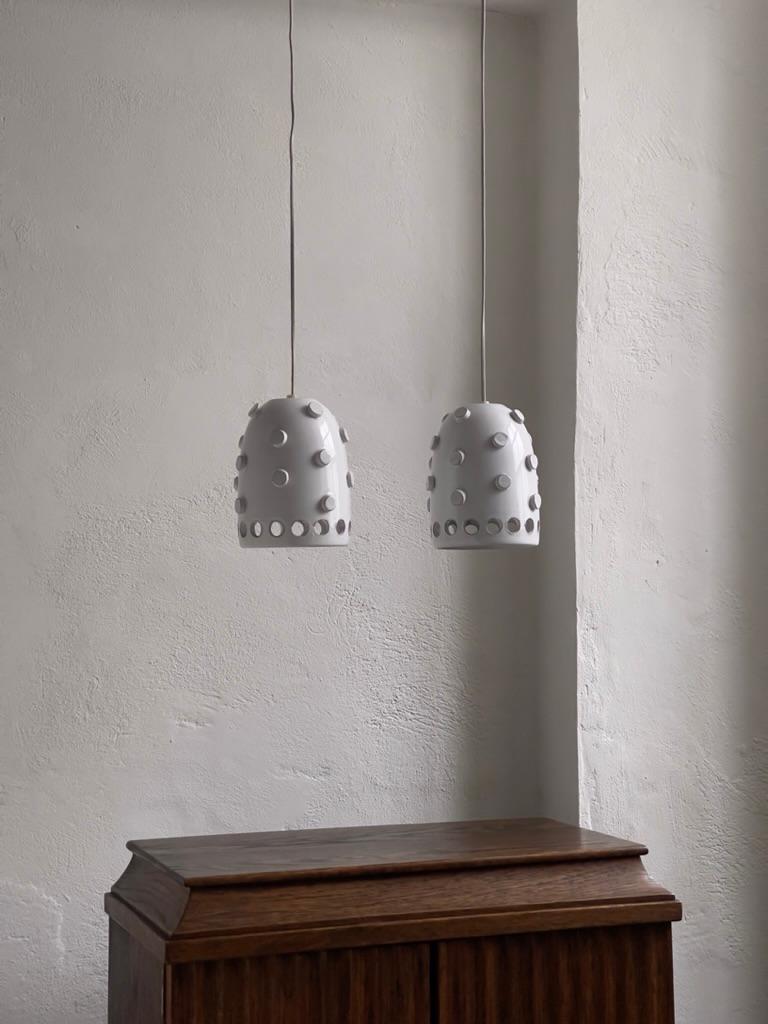 Diese dänischen Keramikanhänger, die in den 1970er Jahren vom renommierten Axella Töpferstudio hergestellt wurden, stellen eine einzigartige Synthese aus Form und Funktion dar, die für das skandinavische Designethos dieser Zeit charakteristisch ist.