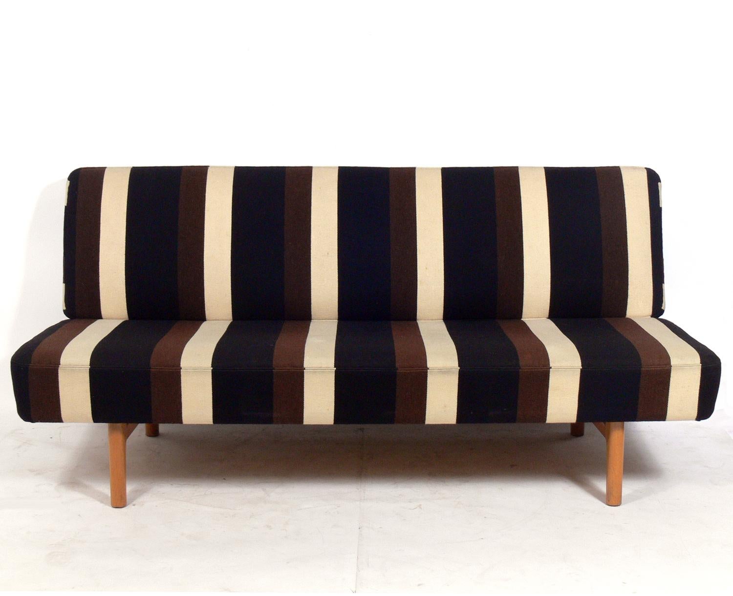 Rare Danish modern sofa, designed by Hans Wegner for Johannes Hansen, Denmark, circa 1950s. This example retains it’s original wool striped fabric. Signed with applied metal manufacturer’s label to underside: [Johannes Hansen Cabinet Makers