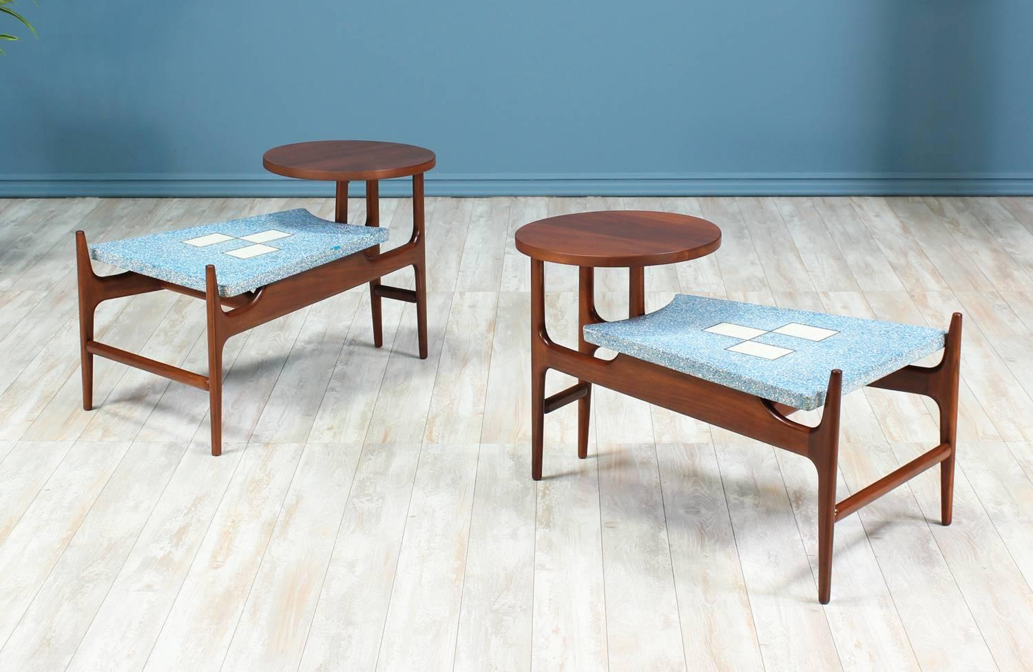 Add a twist of fun and elegance with these fascinating blue terrazzo floating-top side tables designed by Harvey Probber in the United States circa 1950’s. This unique design features a walnut wood frame and a stunning blue terrazzo tile top with