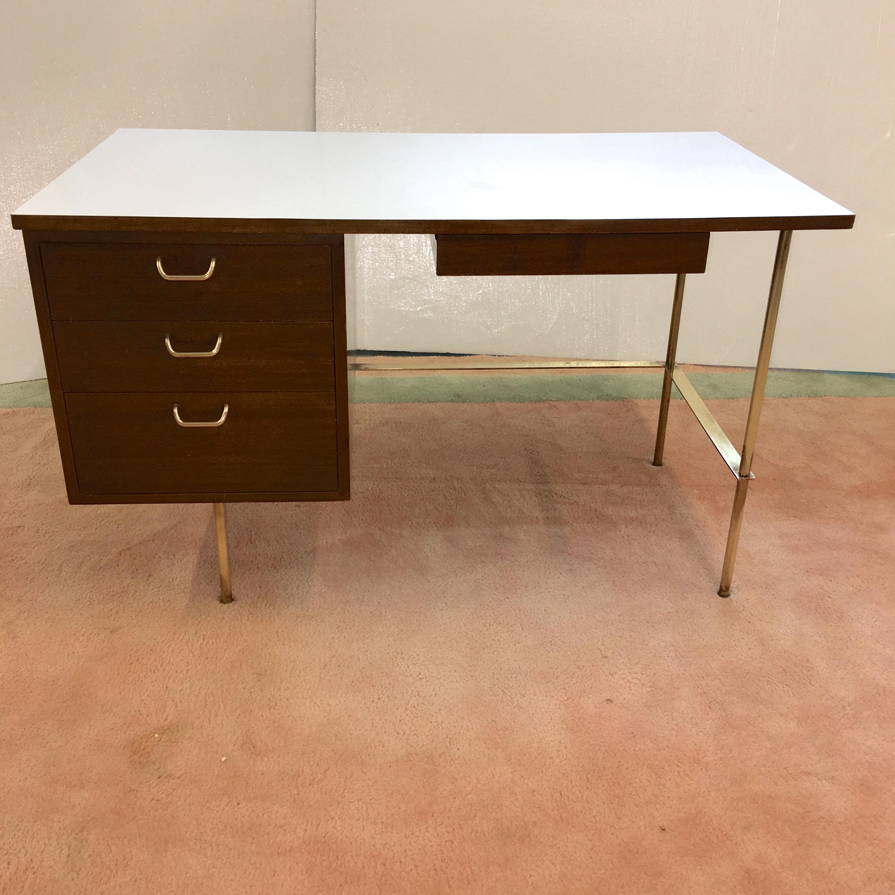 Harvey Probber mahogany writing desk with white laminate top with solid brass tubular legs and solid brass flat bar stretchers.

Left side oriented three drawer case with original solid brass handles. Drawer bottoms also white laminate. 

Harvey