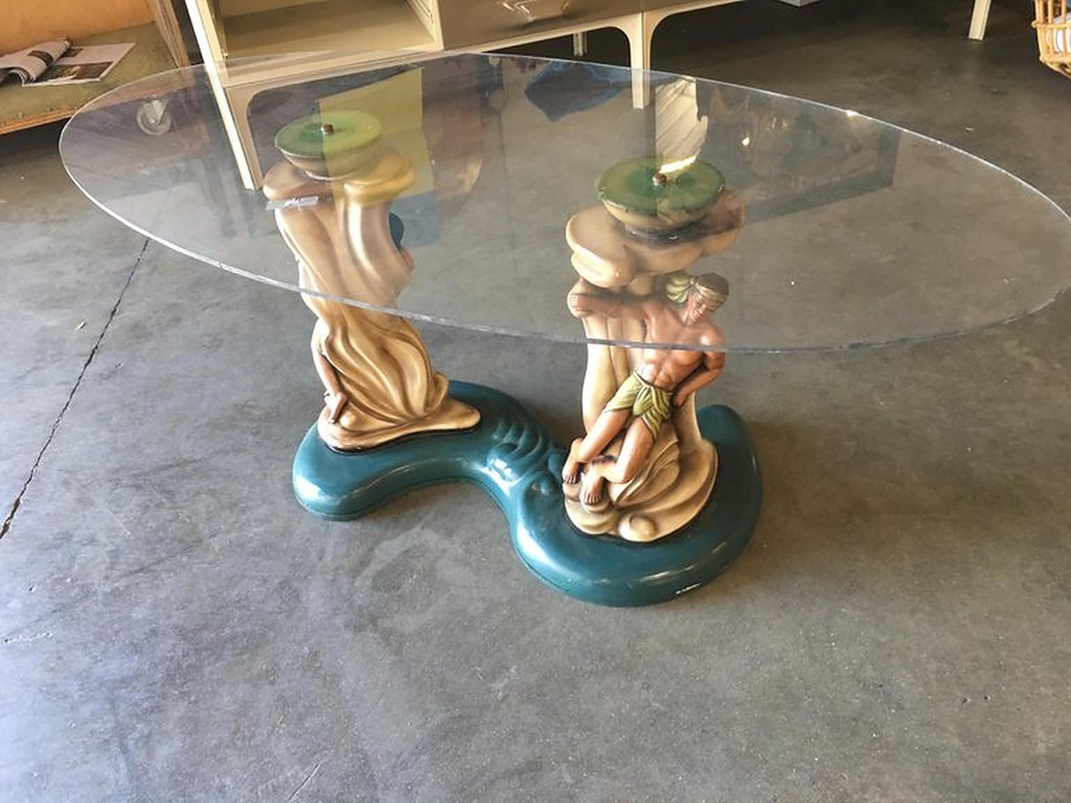 Rare 1950s Hawaiian inspired sculptural chalkware coffee table featuring pacific islander boy and girl lovers leaning against organic structures over a blue ocean like base.