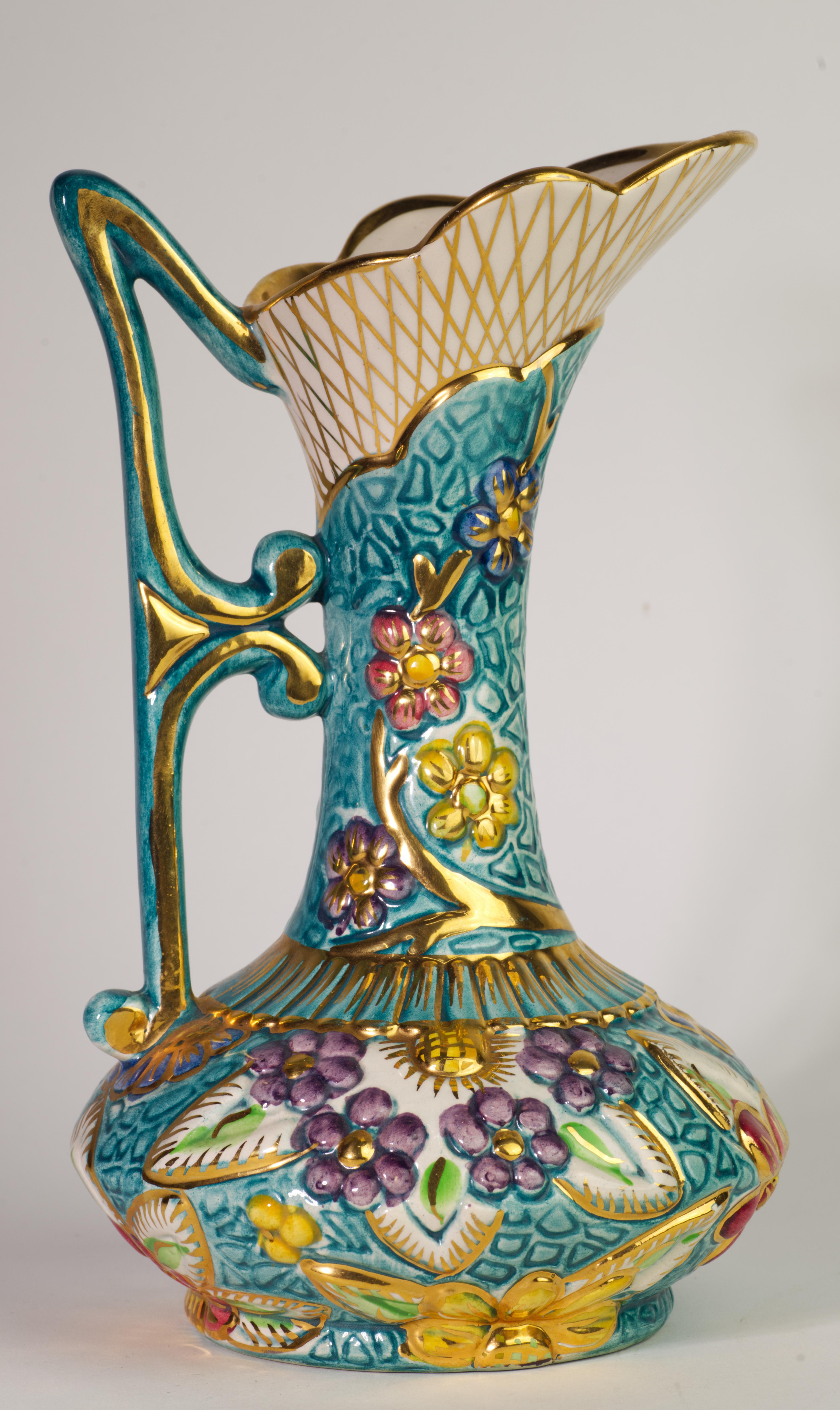  Il raro vaso a brocca in ceramica di Hubert Bequet è decorato con un vivace motivo a rilievo di fiori astratti su uno sfondo verde acqua. Gli accenti dorati attirano l'attenzione sulla texture altamente dettagliata del pezzo e sulla maniglia