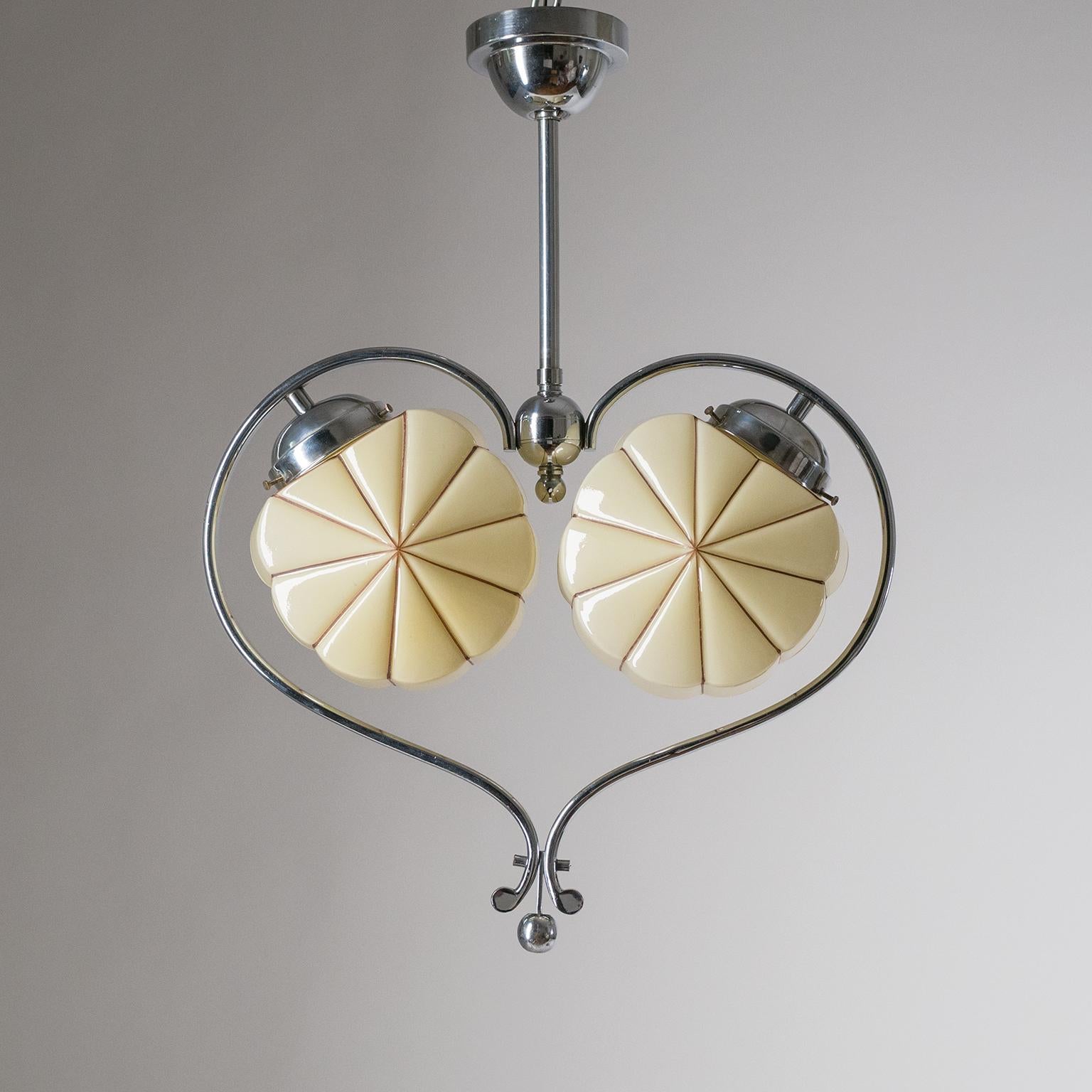 Very unique heart shaped Art Deco chandelier from the 1930s. This unusual lyrical design consists of chromed brass hardware and two cased and hand-painted glass diffusers. The base tone of the glass is ivory with brown striped decor. Nice original