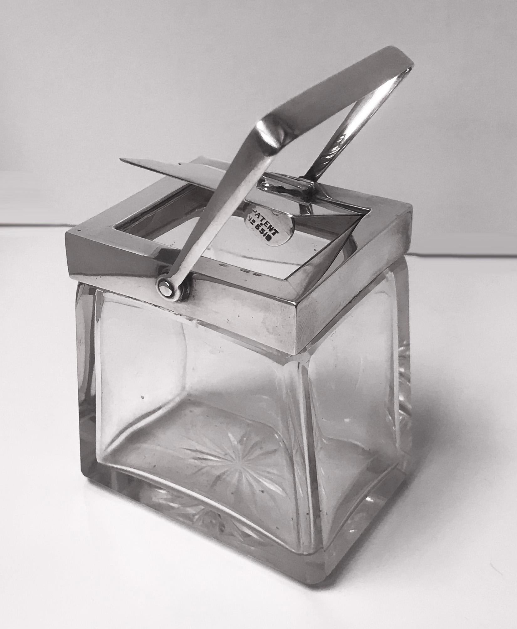 Very rare Heath and Middleton (Hukin and Heath) glass and silver mechanical condiment jar, Birmingham, 1906. Full hallmarks to handle, mount and cover and design No 18226 and Patent No 5518. Hinged cover fitted with unique mechanical handle which