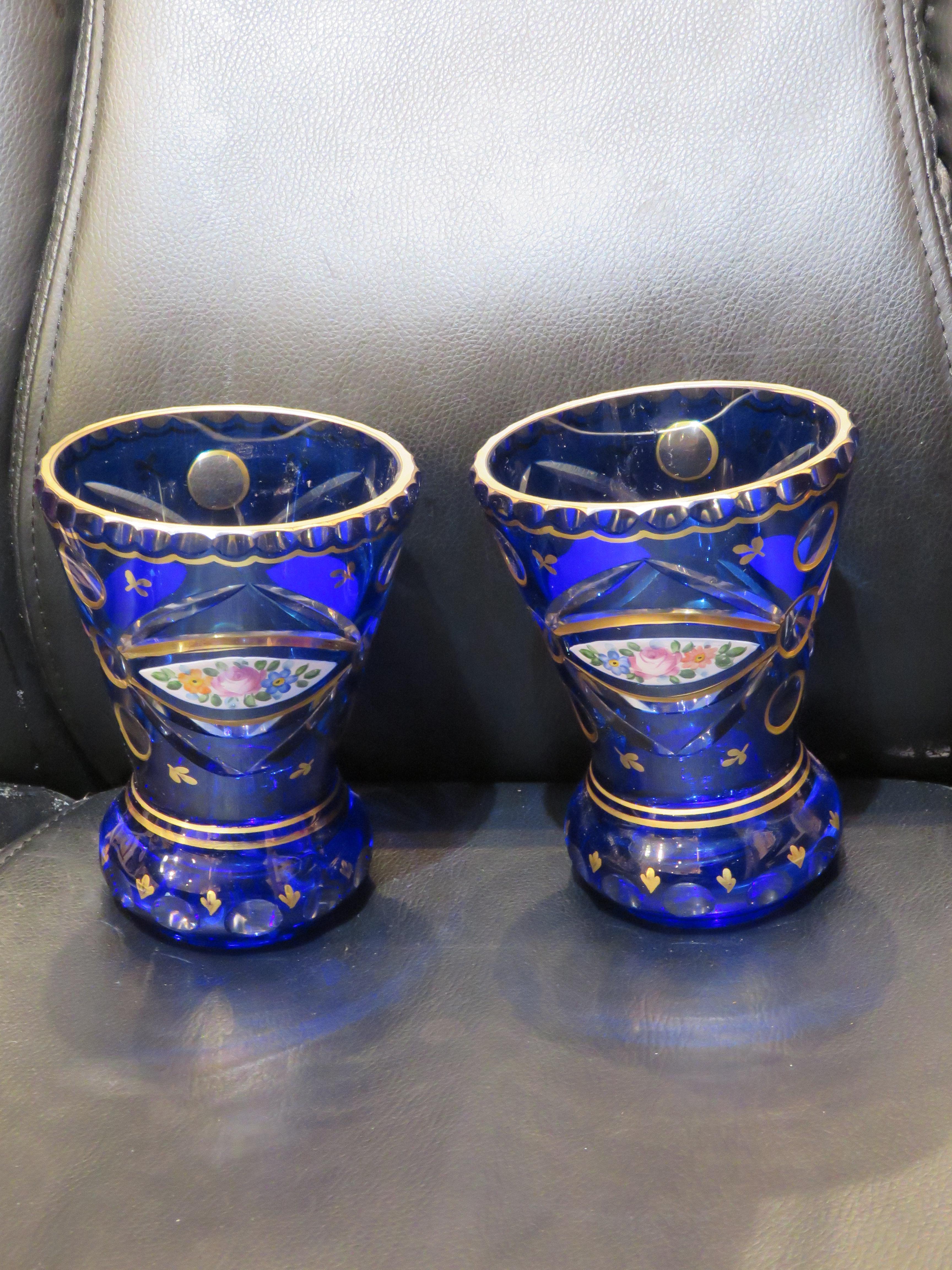 Une paire rare de VASES EN VERRE BLEU COBALT DE MOSER BOHÉMIEN. Les vases sont magnifiquement réalisés avec des détails de feuilles d'or en volutes et des fleurs finement peintes sur l'ensemble du vase.  Prise d'une importante propriété dans l'Upper