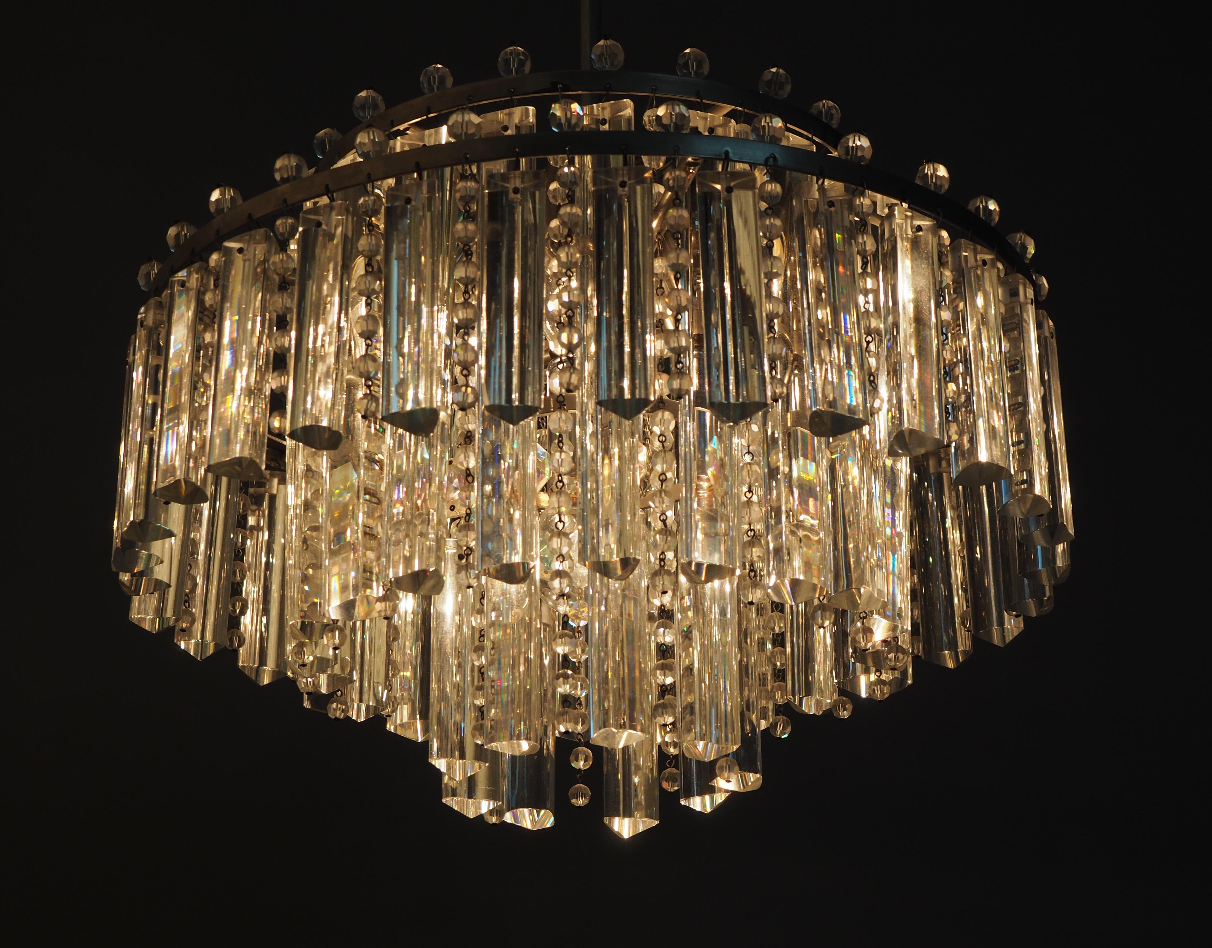 Rare model of three - tiered six-light glass chandelier by Palwa, circa 1960s.
The fixture is made of silver color patinated and heavy triangular glass rods and strass- prism.
Floodlight prisms give this chandelier a striking shape; only selected
