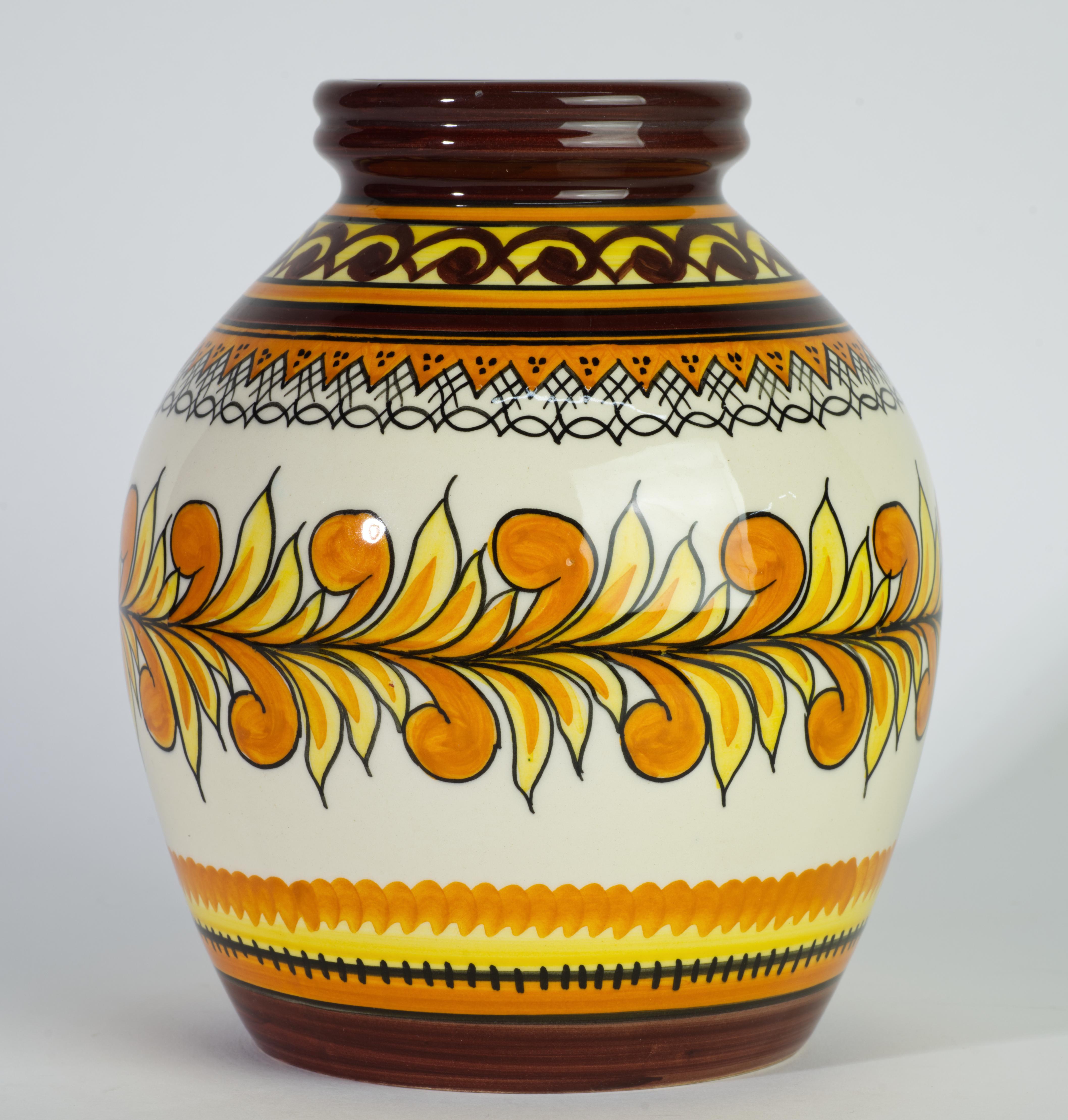   Rare Henriot Quimper faience vase is hand painted with abstract decor of complex geometric bands on the base and on top and abstract leaf garland in the central area of the vase. Minimal yellow, orange, and chocolate brown palette prevents the