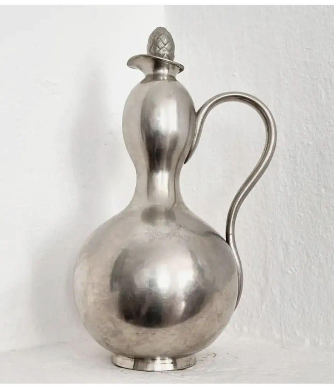 Rare wine pitcher in pewter, gourd-shaped and pine cone-shaped cap. Made by Herman Bergman Konstgjuteri, Stockholm. Stockholm and the makers hallmark, dated 1931 (E8)

In nice condition, normal wear and signs of age. One shallow dent - seen in
