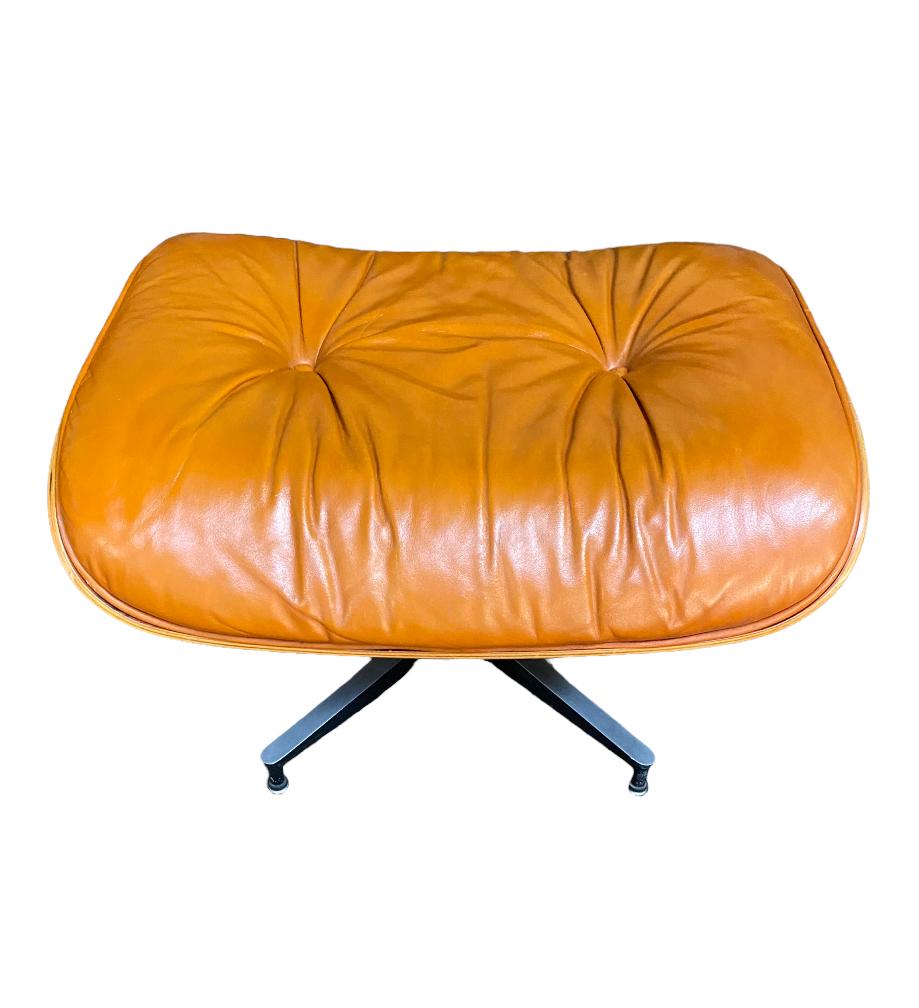 Gorgeous original Herman Miller Eames ottoman in rosewood and custom burnt orange leather. Vintage custom order, extremely difficult to find in this stunning shade. Aluminum frame and wooden shell in good condition. Manually adjustable feet. Leather