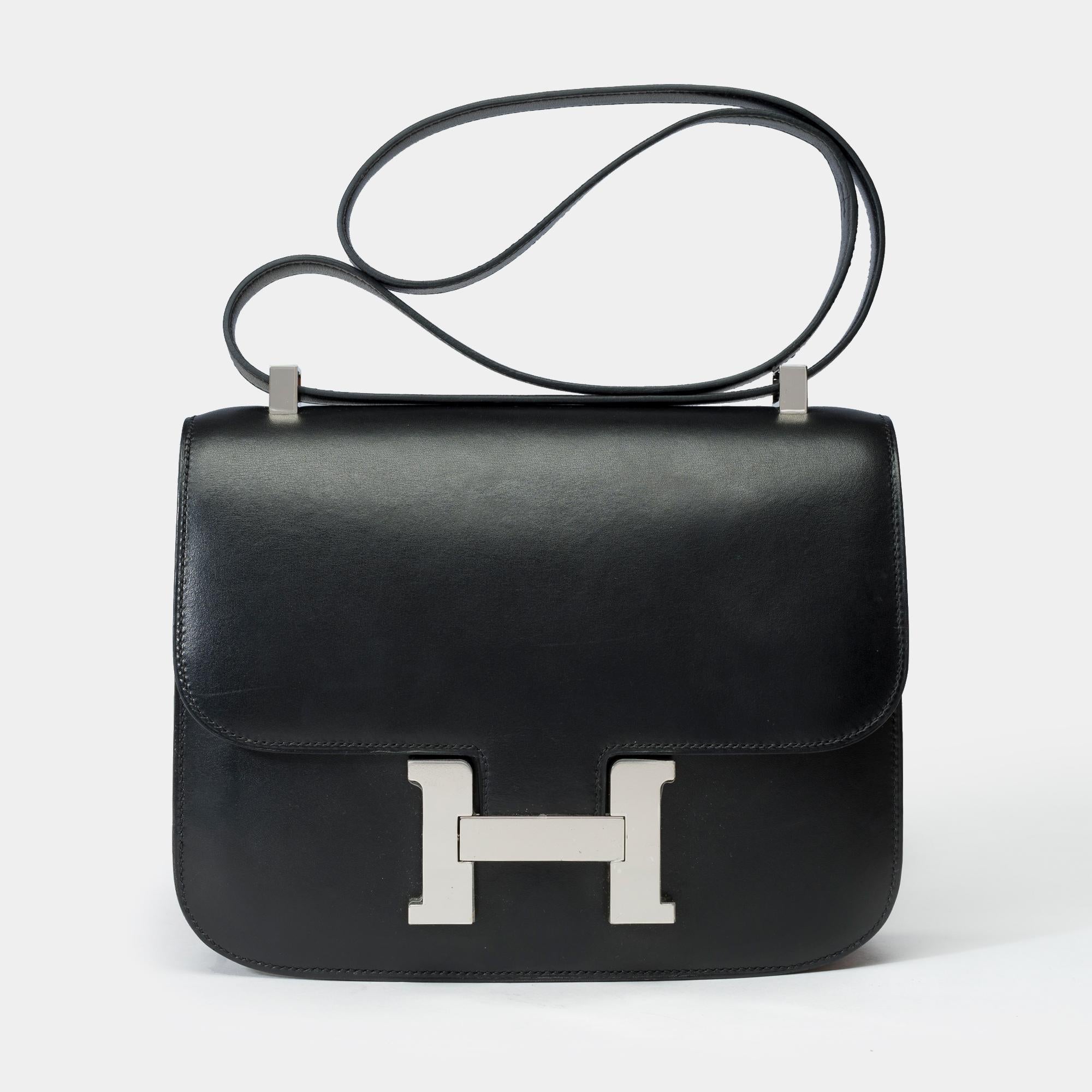 Sublime​ ​Hermès​ ​Constance​ ​23​ ​shoulder​ ​bag​ ​in​ ​black​ ​box​ ​calfskin,​ ​silver​ ​palladium​ ​metal​ ​trim,​ ​a​ ​black​ ​box​ ​leather​ ​shoulder​ ​strap​ ​for​ ​shoulder​ ​or​ ​crossbody​ ​carry

Logo​ ​closure​ ​on​ ​flap
Black​