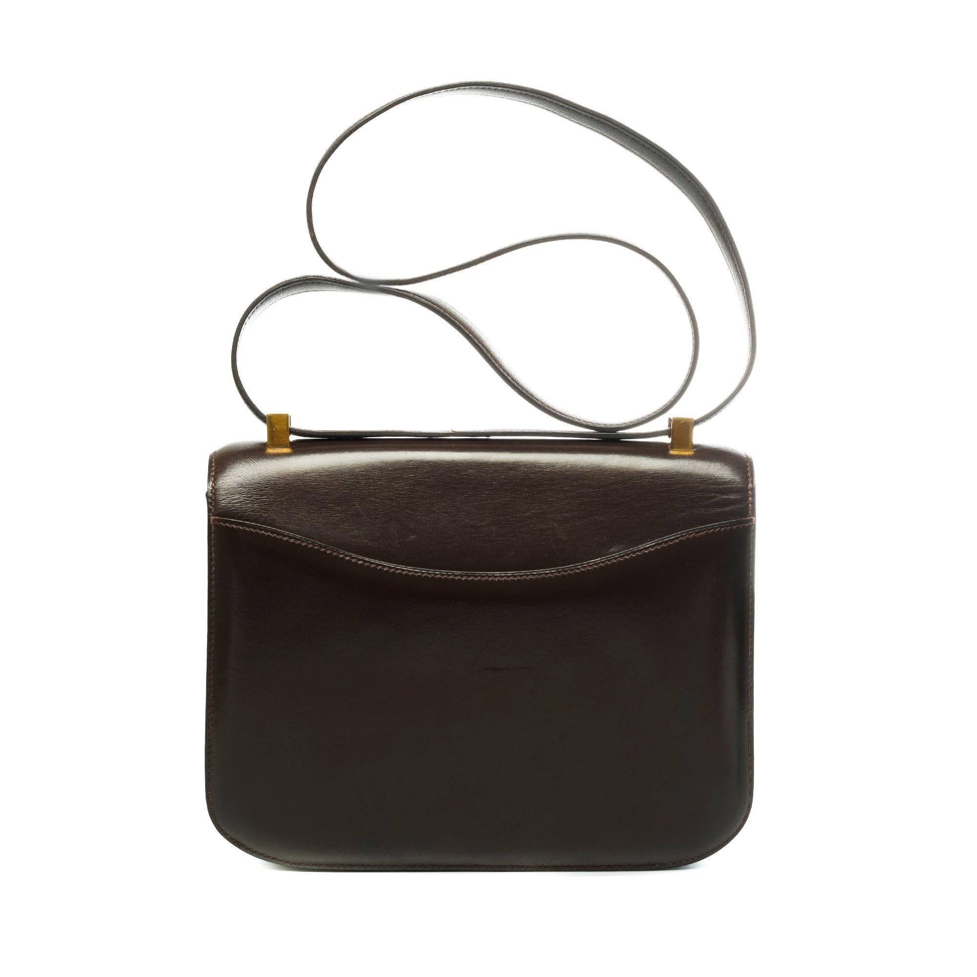 Splendid Hermes Constance Handbag 23 cm in brown box leather, gold metal hardware, brown leather handle transformable allowing a hand or shoulder support.

Closure marked H on flap.
A patch pocket on the back of the bag.
Lining in brown leather, a