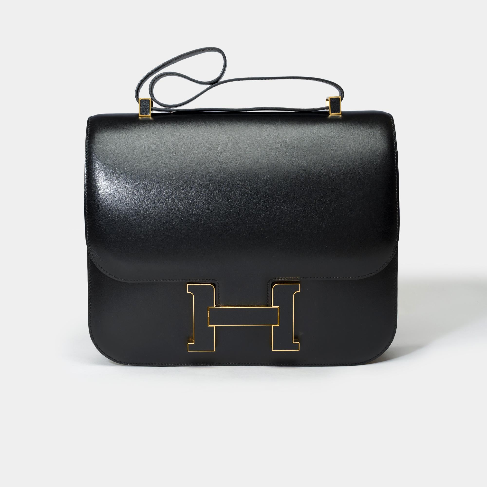 Extremely​ ​Rare​ ​and​ ​sought​ ​after​ ​Limited​ ​edition​ ​Hermès​ ​Constance​ ​Cartable​ ​shoulder​ ​bar​ ​in​ ​black​ ​box​ ​calfskin​ ​leather,​ ​​ ​​ ​gold​ ​plated​ ​metal​ ​trim,​ ​a​ ​black​ ​box​ ​leather​ ​handle​ ​for​ ​a​ ​hand​ ​or​
