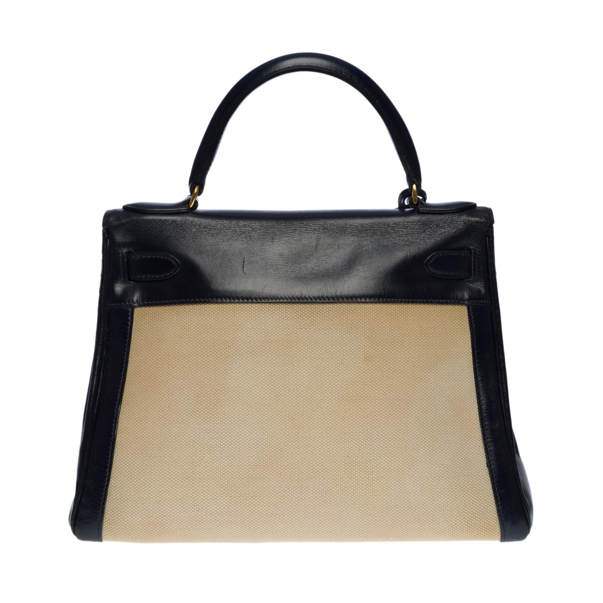 Rare Hermes Kelly 28 retourne handbag bi-material in navy blue leather box and beige canvas, gold plated metal hardware, navy blue leather handle allowing a hand-carry

Flap closure
Marine leather lining, a large patch pocket, a double patch