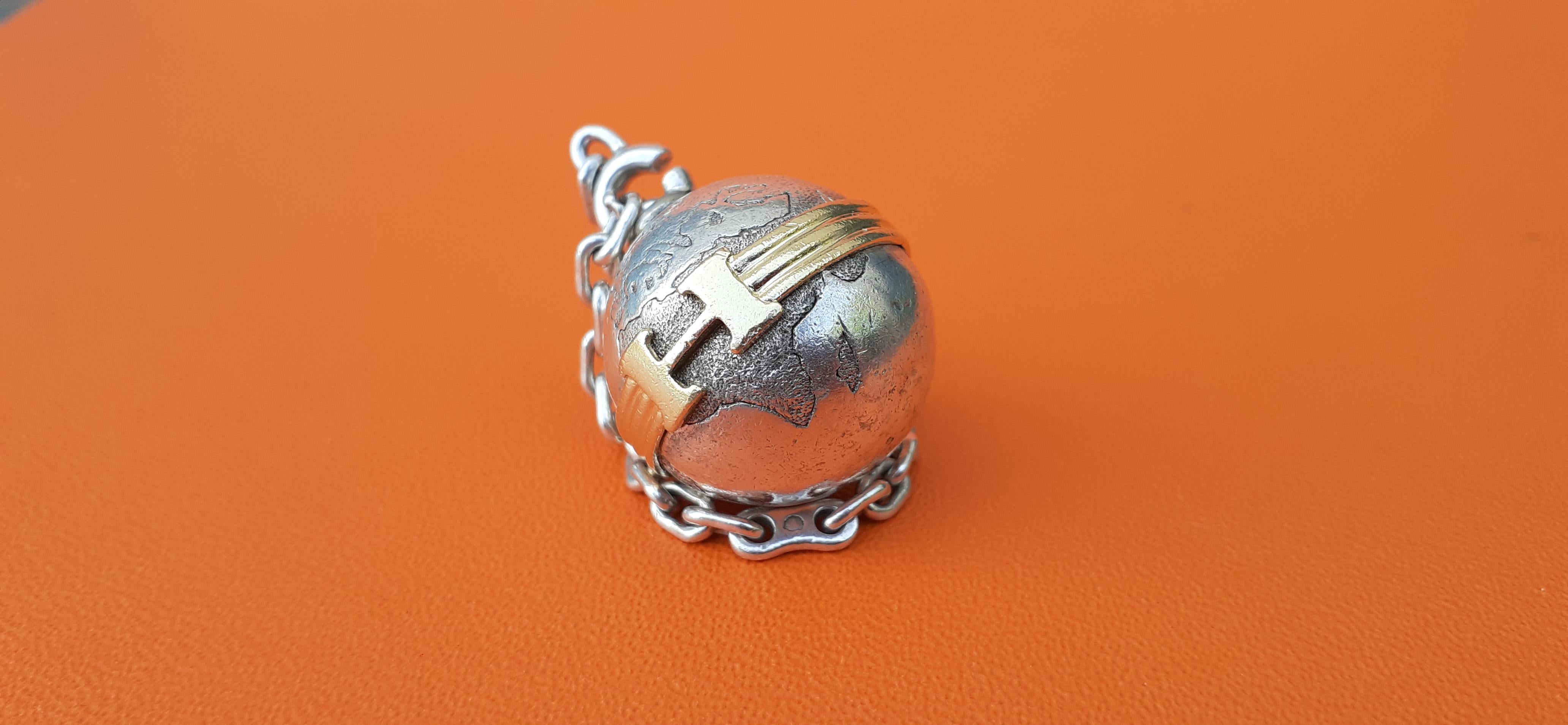 Rare Authentic Hermès Charm or Keychain

In shape of a Globe

Can be used as Bag Charm or Key Ring

Made of Silver (minerva hallmark)

The globe is belted in golden with an 