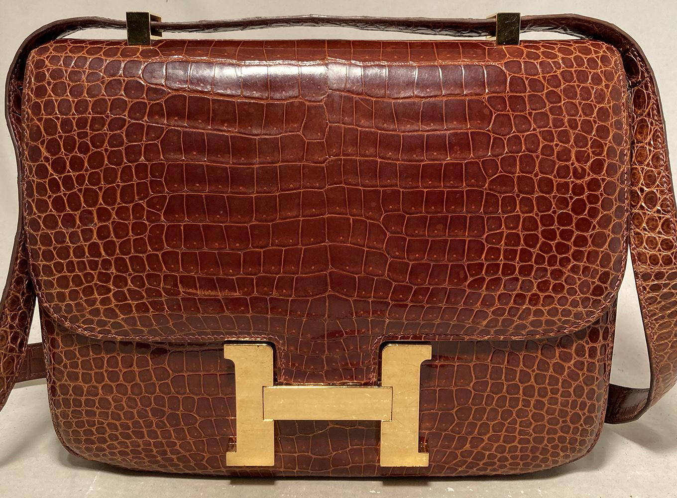 RARE Hermes Brown Crocodile Constance Bag in very good condition. Cognac brown crocodile leather exterior trimmed with matching crocodile leather shoulder strap and gold H hardware along front side. Back side exterior slit pocket. Magnetic lift flap