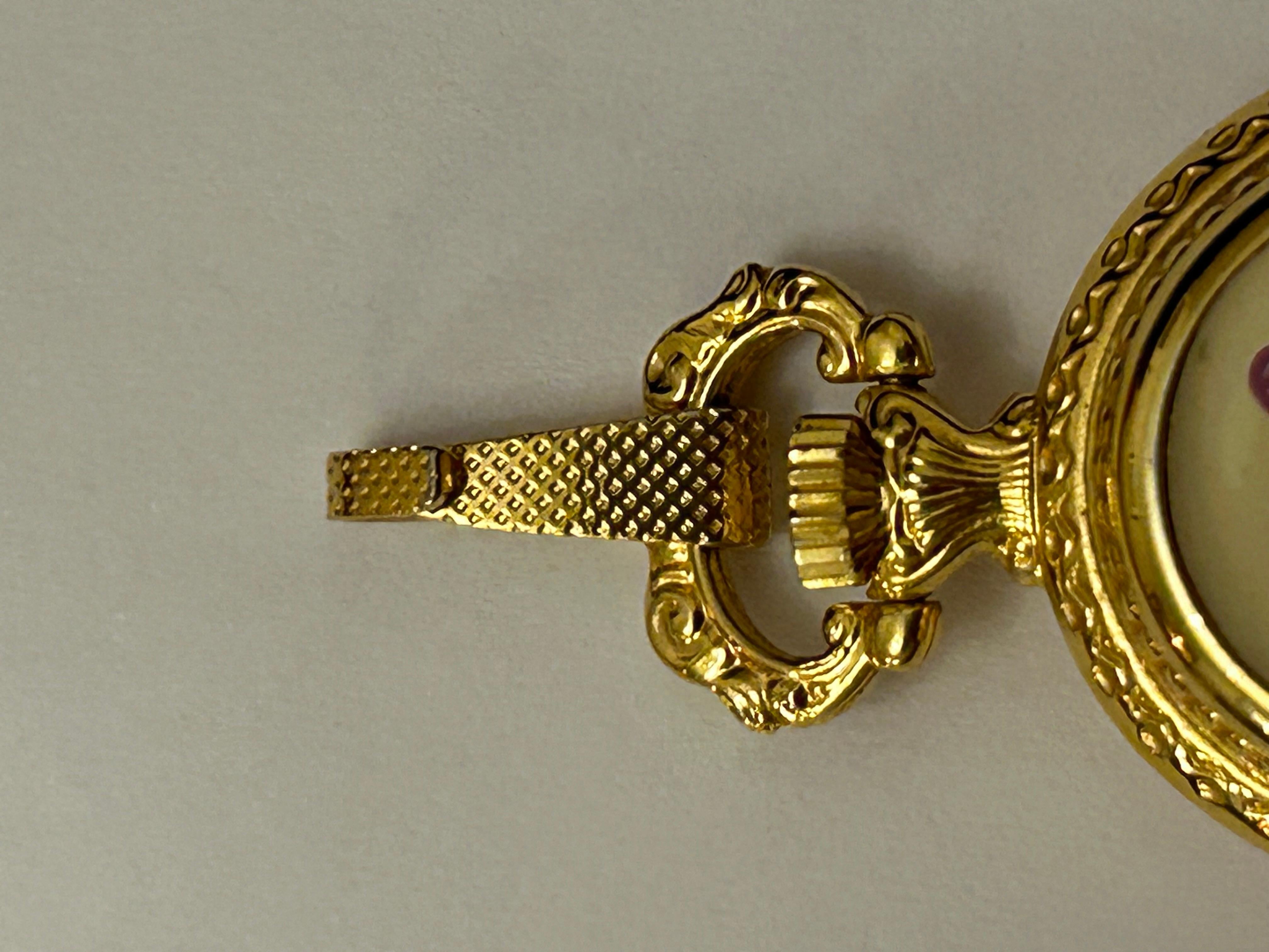 Äußerst seltene authentische Hermes Vintage-Uhr. 
Schöne Uhr in einem goldenen Metall-Anhänger eingeschlossen, ist die Vorderseite schön dekoriert Emaille mit Blumen gedruckt.  Lila, rosa und grün, wie ein schöner Blumenstrauß.
So einzigartig, wie