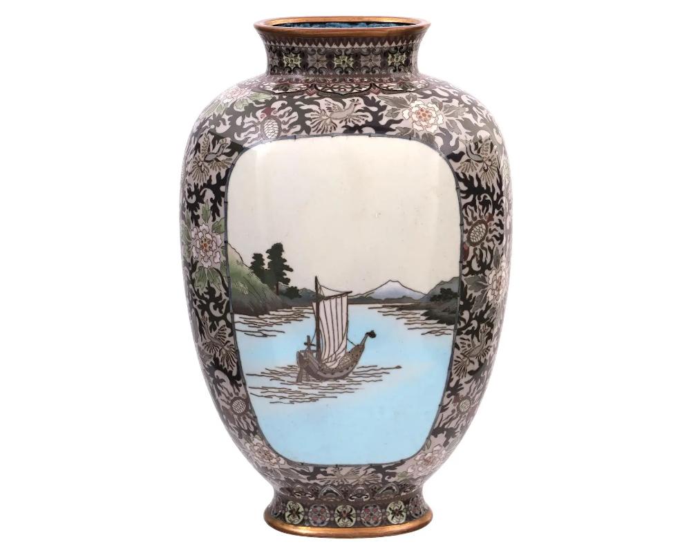 A rare high quality antique Japanese, late Meiji period, enamel over gilt copper vase. The urn shaped vase has a wide fluted neck. The ware is enameled with polychrome medallions depicting a ship in a river mountain landscape and blossoming flowers