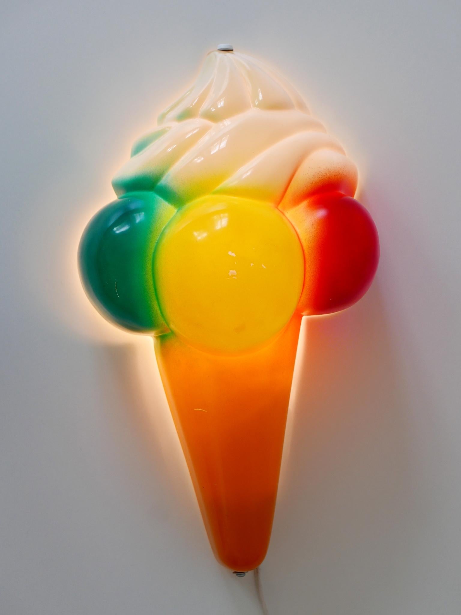 Rare and highly decorative vintage sconce or wall lamp in shape of an ice cream cone. Manufactured probably in Germany, 1980s.

Executed in colored plastic and metal, the wall lamp is executed with  1 x E14 / E12  Edison screw fit bulb socket. It is