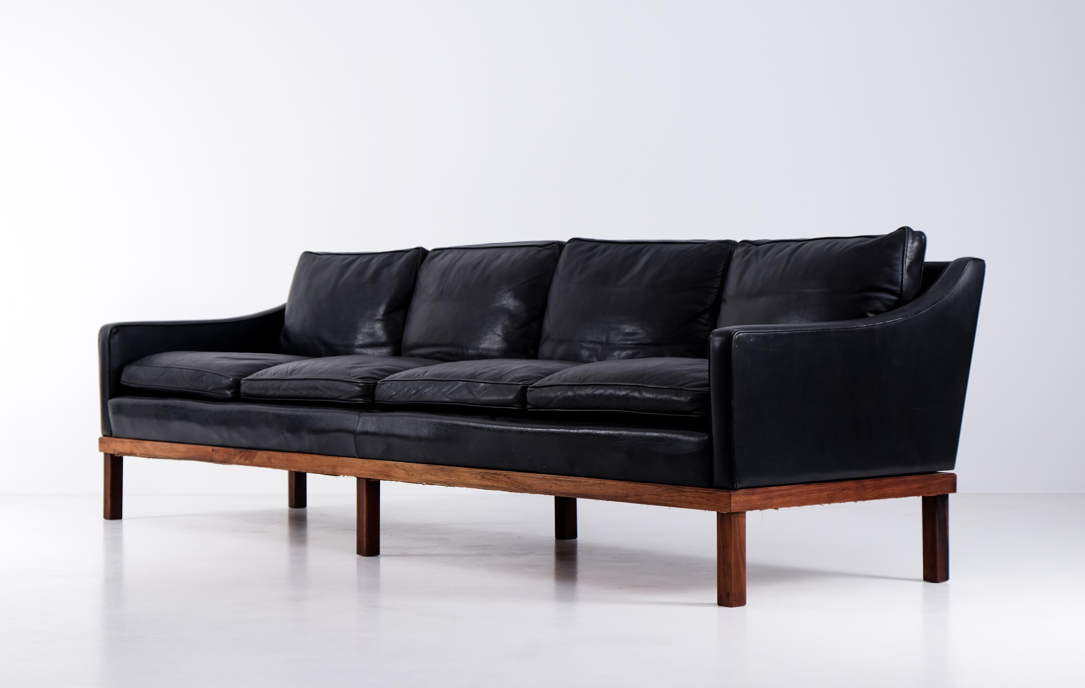 Rare 4-seater Ib Kofod Larsen sofa in original black leather, very good condition. Produced by OPE in Sweden, 1960s.
 