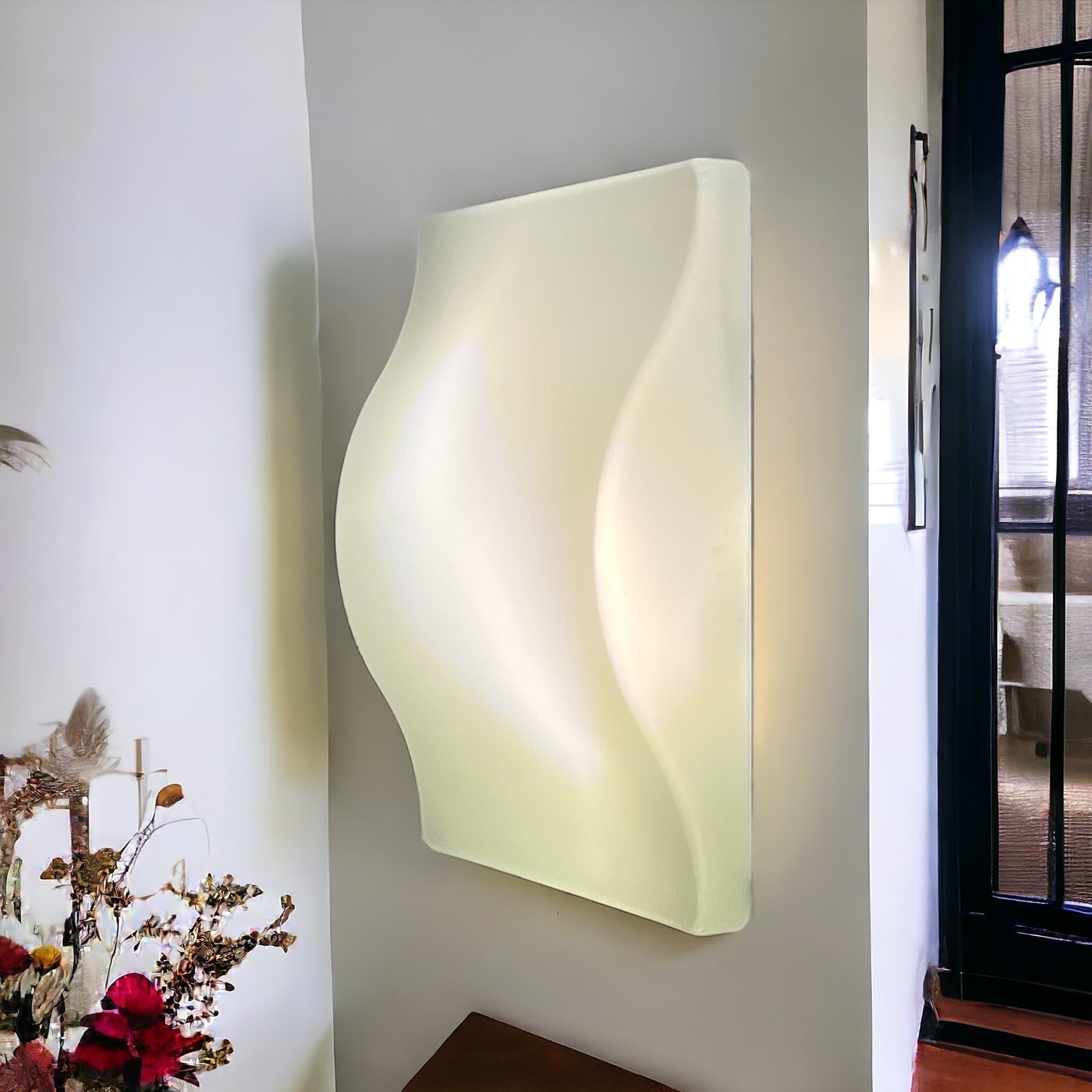 Boasting a sinuous shape and a translucent white hue, this lamp exudes timeless sophistication and versatility. Its generous size makes it perfect for illuminating large rooms or studios, whether mounted on the wall or ceiling. Whether used as a