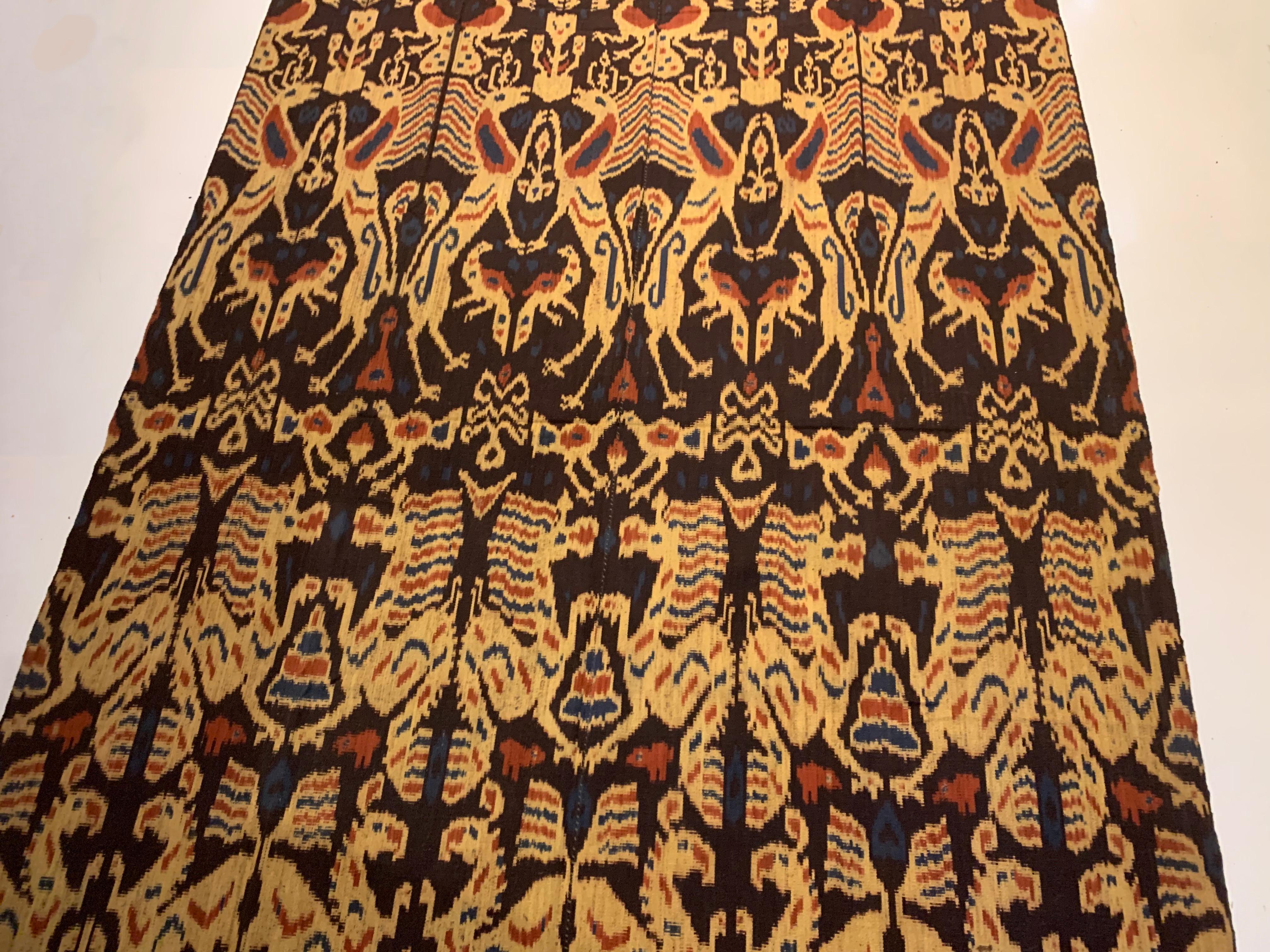 Dieses Ikat-Textil stammt von der Insel Sumba in Indonesien. Es wird mit natürlich gefärbten Garnen nach einer seit Generationen überlieferten Methode handgewebt. Es zeigt eine atemberaubende Vielfalt an unterschiedlichen Stammesmustern und -motiven