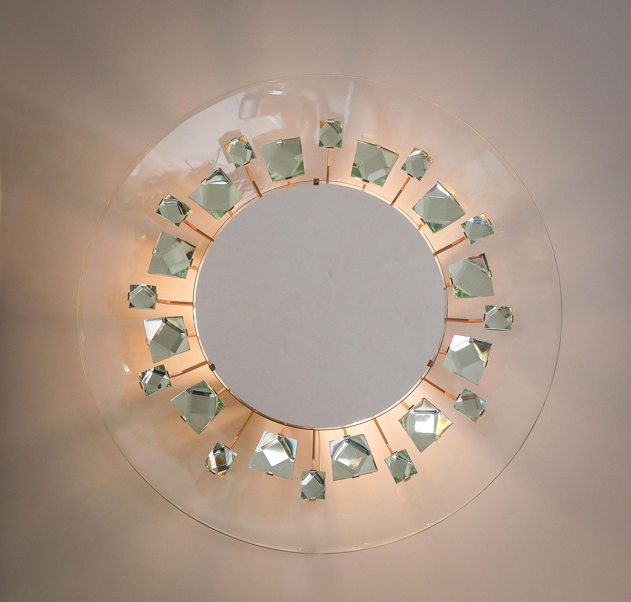 Rare Illuminated Mirror by Max Ingrand for Fontana Arte Model Pistil 2044. Having 24 cut crystal chunks attached to articulating brass arms. Framed by a curved concave glass back-plate and centered with a mirror concealing 3 candelabra