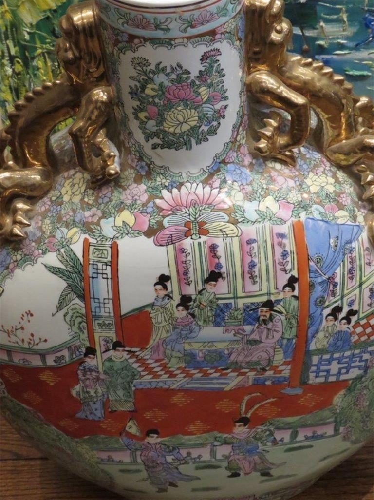 Il seguente articolo è una rara e importante coppia di vasi cinesi dipinti a mano in stile QIALONG con medaglione a rosa. Magnificamente realizzato con ritratti di figure e paesaggi asiatici. Su ogni lato ci sono maniglie in foglia d'oro a forma di