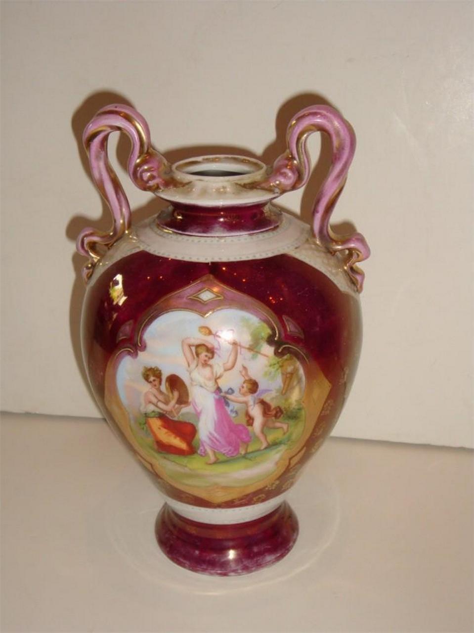 The Following Item we are Offering is a Rare Antique Hand Painted Austria Centerpiece Vase Urn. Beautifully Handpainted in Hues of Reds, Pink , and White Colors with Portraits of Beautiful Scenes and Both Sides of each and Signed Kaufman. Stamped on