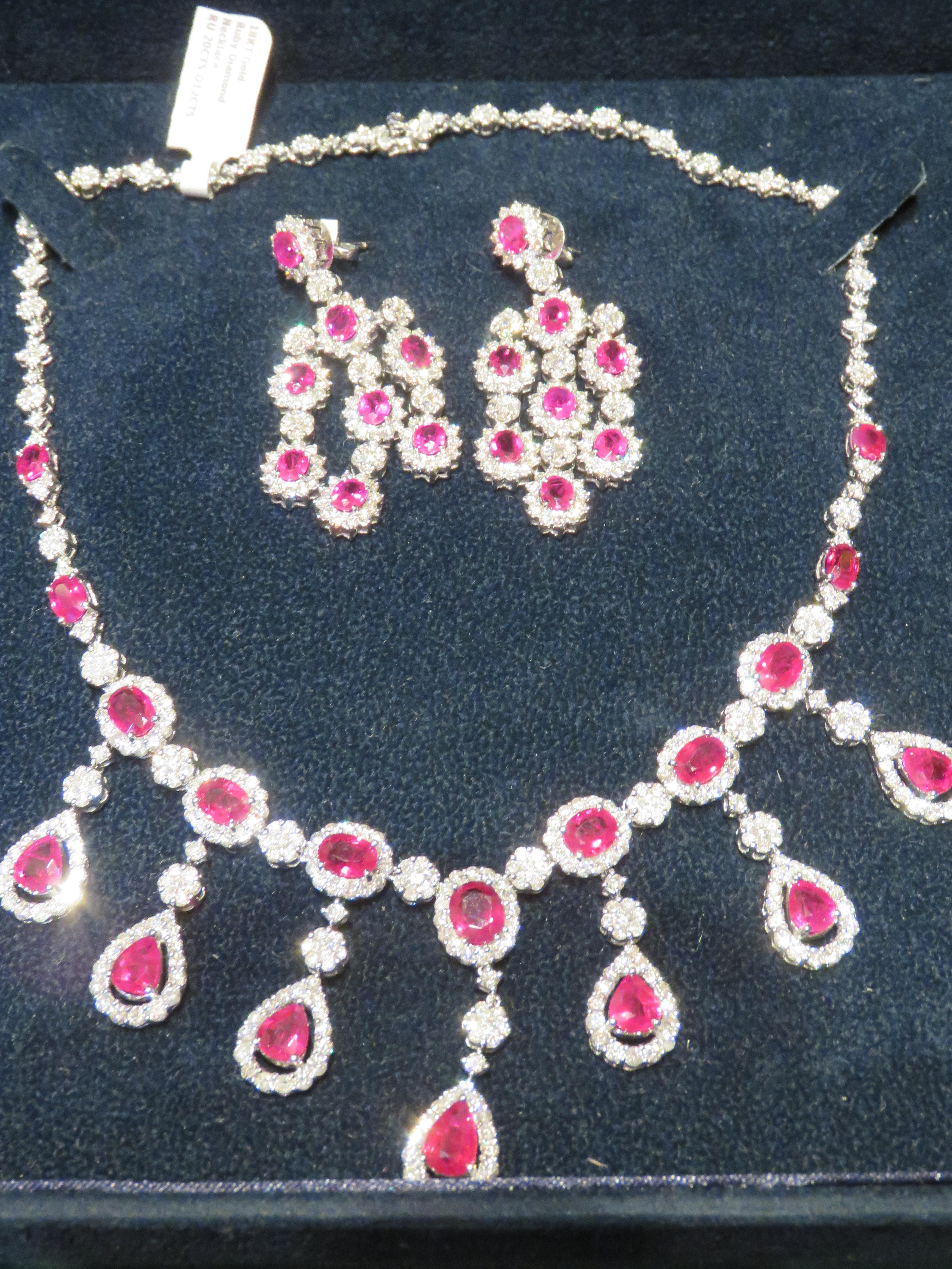 The Following Items we are offering is a Rare Important Radiant 18KT White Gold Necklace and Earring set consisting of Pear and Oval Shaped Glittering Rubies and Magnificent Diamonds Throughout. Features Large Faceted Rubies of the Finest Quality
