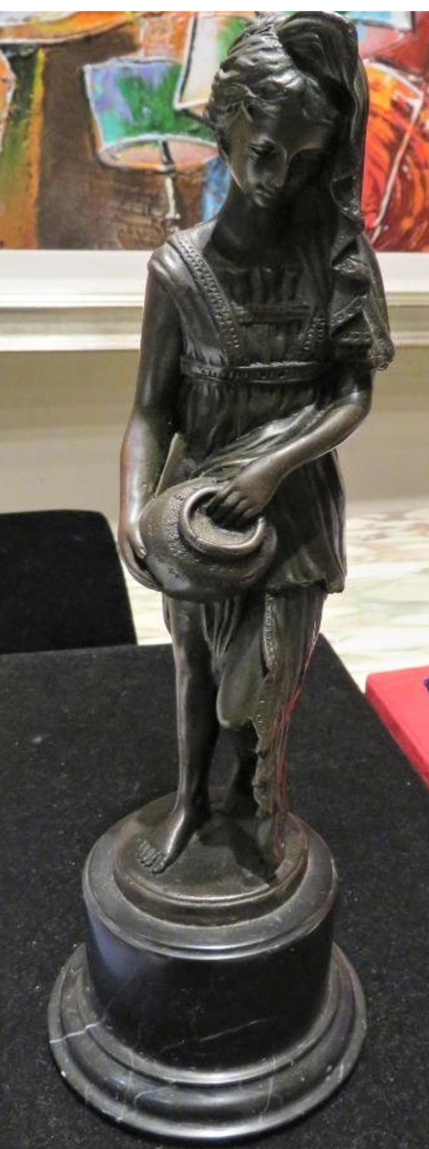 L'article suivant est une magnifique sculpture en bronze de qualité muséale représentant une femme magnifiquement drapée tenant une cruche. Le bronze est finement exécuté, avec des détails exceptionnels et une patine fine, et repose sur un socle en