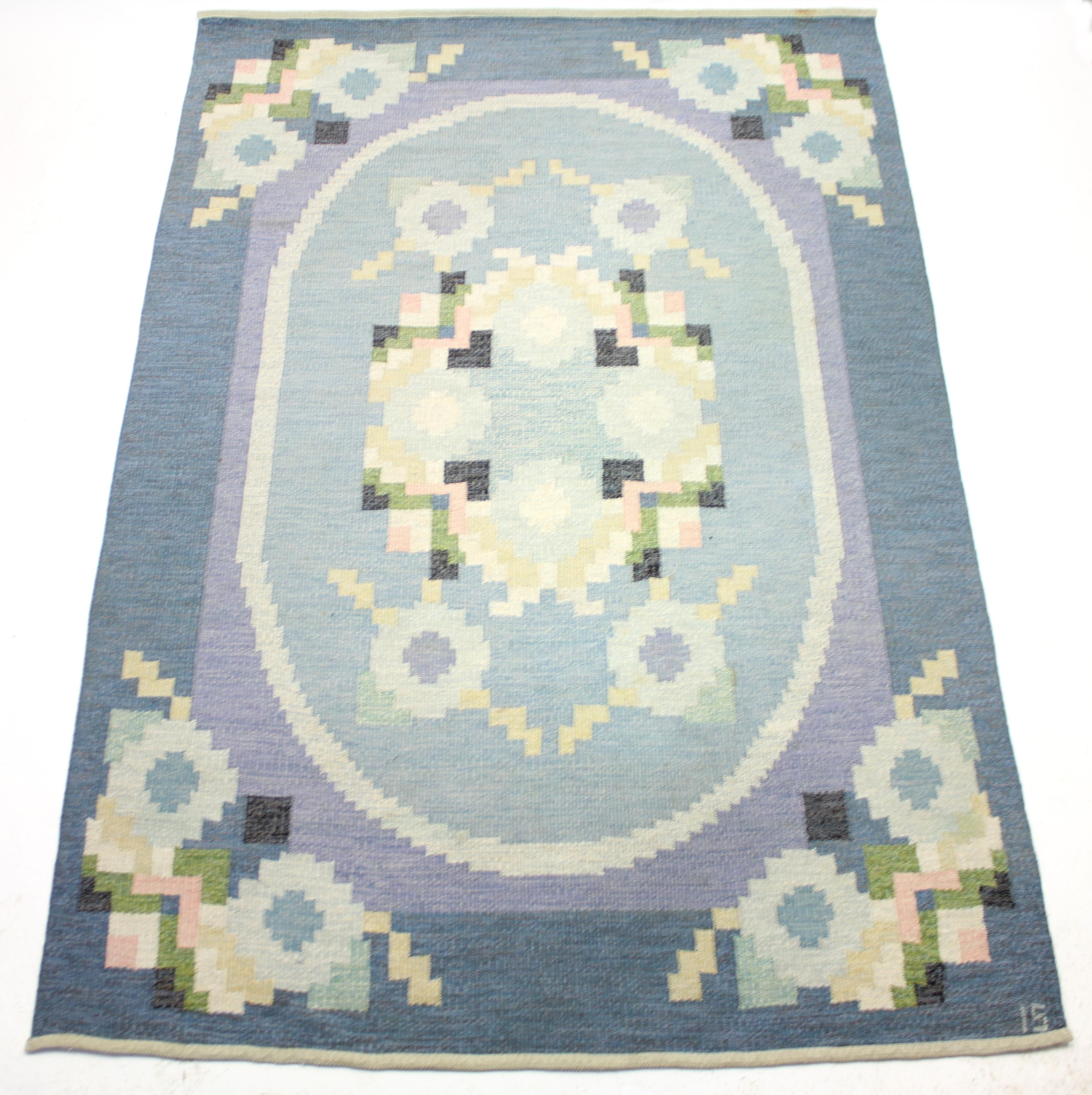 Flat weave Röllakan carpet designed by Ingered Silow in the 1950s. Very rare motif with butterflies in the corners. Main colours are different hues of blue with a dose of purple, pink, black and green. Newly cleaned by a professional carpet cleaning
