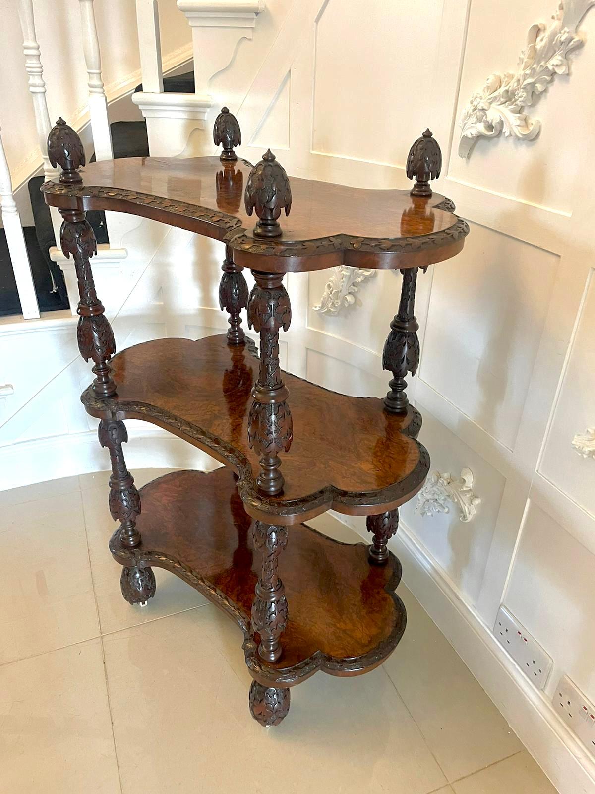 Rare Irish antique Victorian exhibition quality freestanding burr walnut carved whatnot having three serpentine shaped exhibition quality burr walnut tiers with a finely carved edge, profusely carved finals to the top united by profusely carved